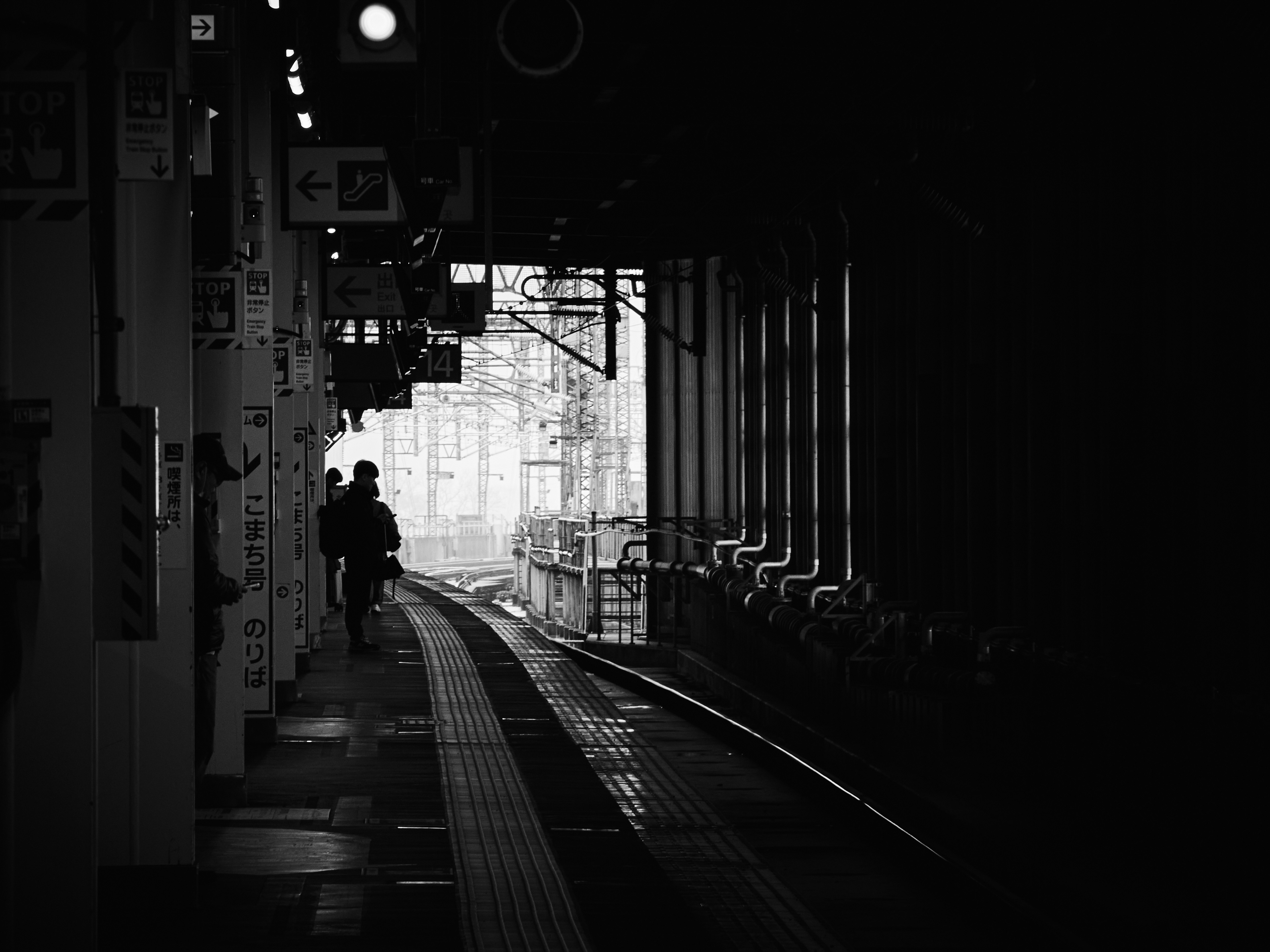 ทางเดินมืดที่มีรางรถไฟทอดยาวไปไกลและป้ายต่างๆ