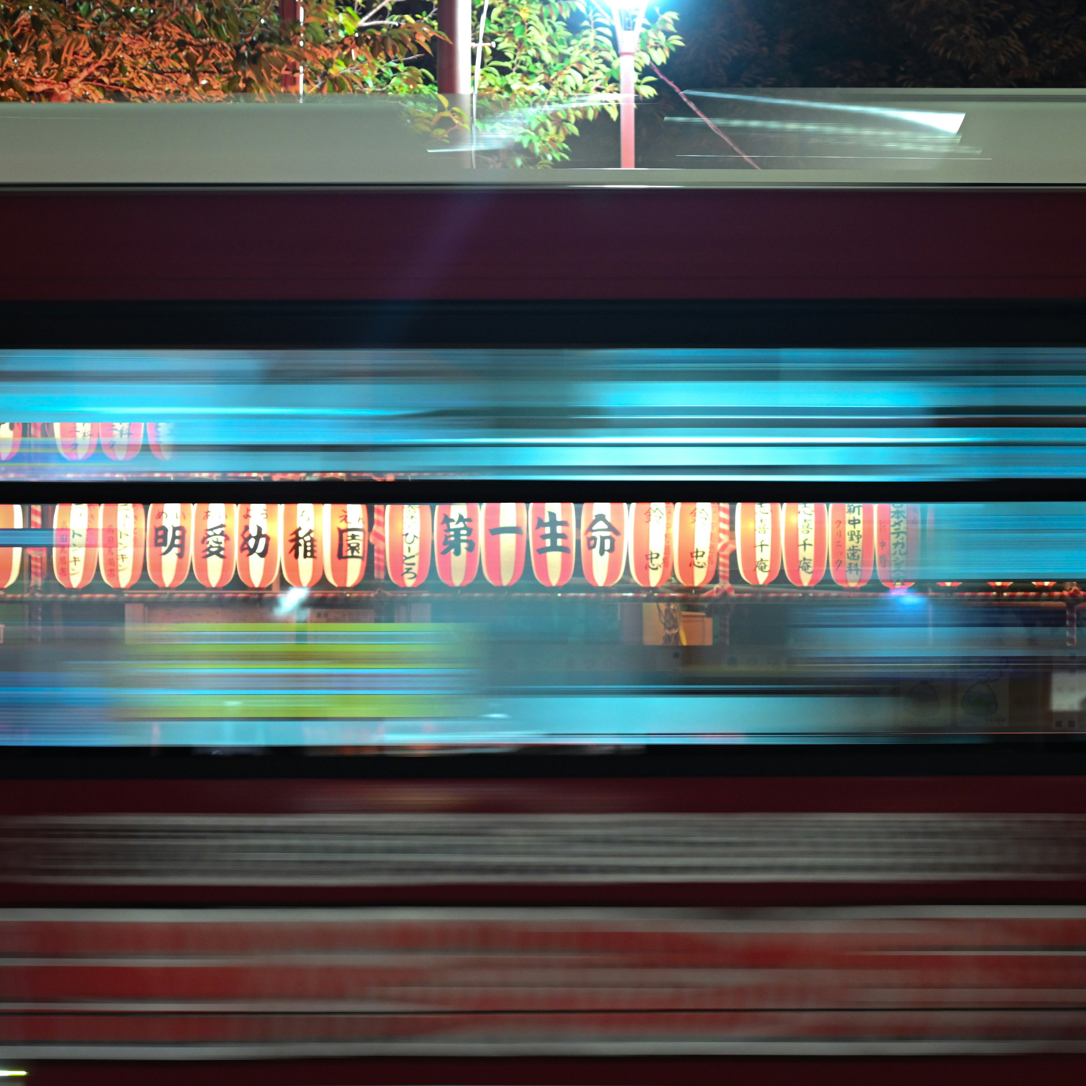 夜の東京を走るバスの車窓と提灯の光
