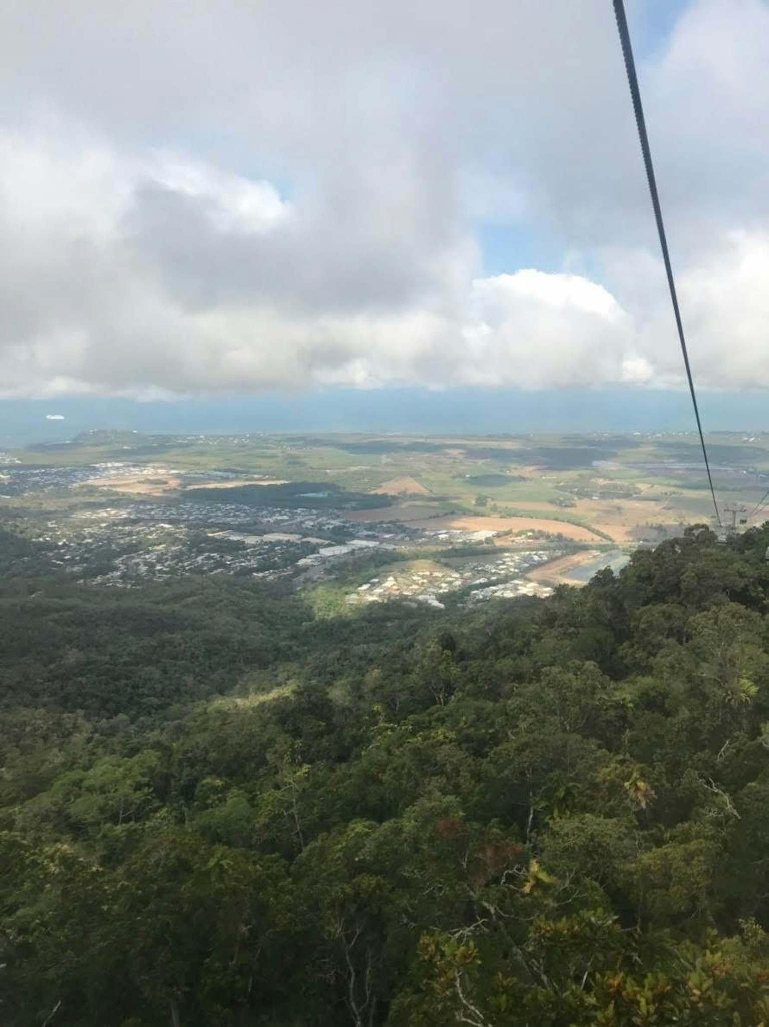 Pemandangan indah dari puncak gunung pohon hijau subur dan tanah luas di bawah langit mendung
