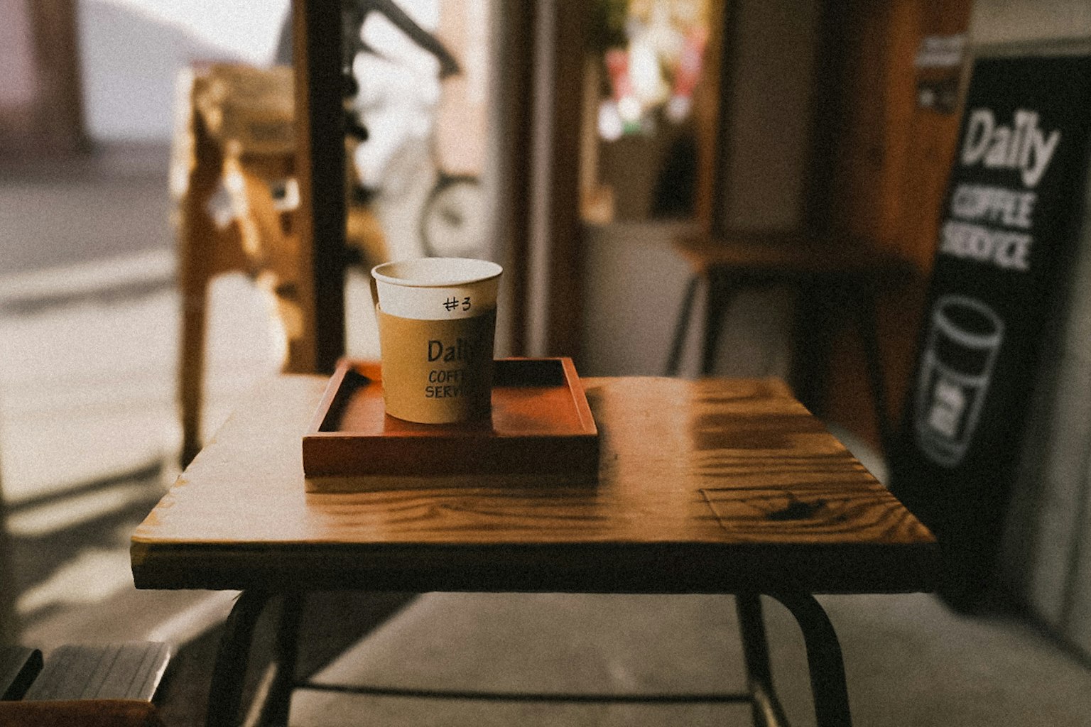 木製のテーブルの上に置かれたコーヒーカップとトレイの写真