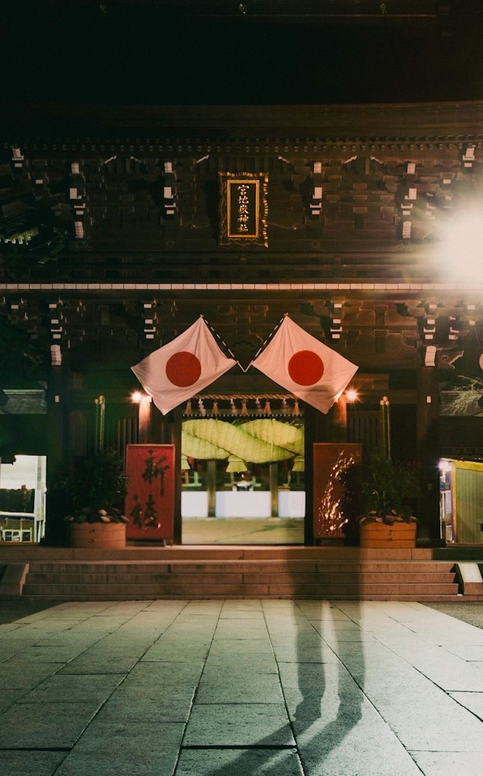 Vue nocturne d'un bâtiment traditionnel avec des drapeaux japonais affichés