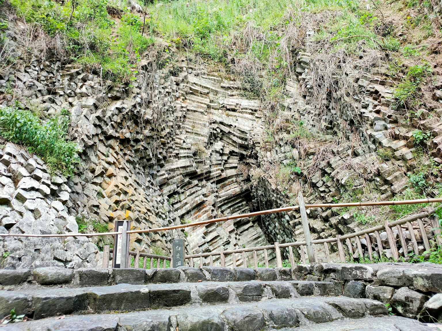 Treppe zu einer Felsklippe mit geschichteten Gesteinsformationen