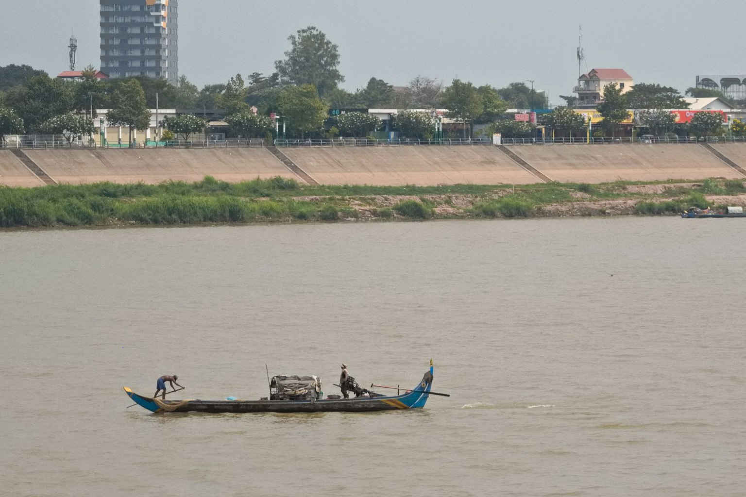 Sebuah perahu kecil di sungai dengan latar belakang garis kota