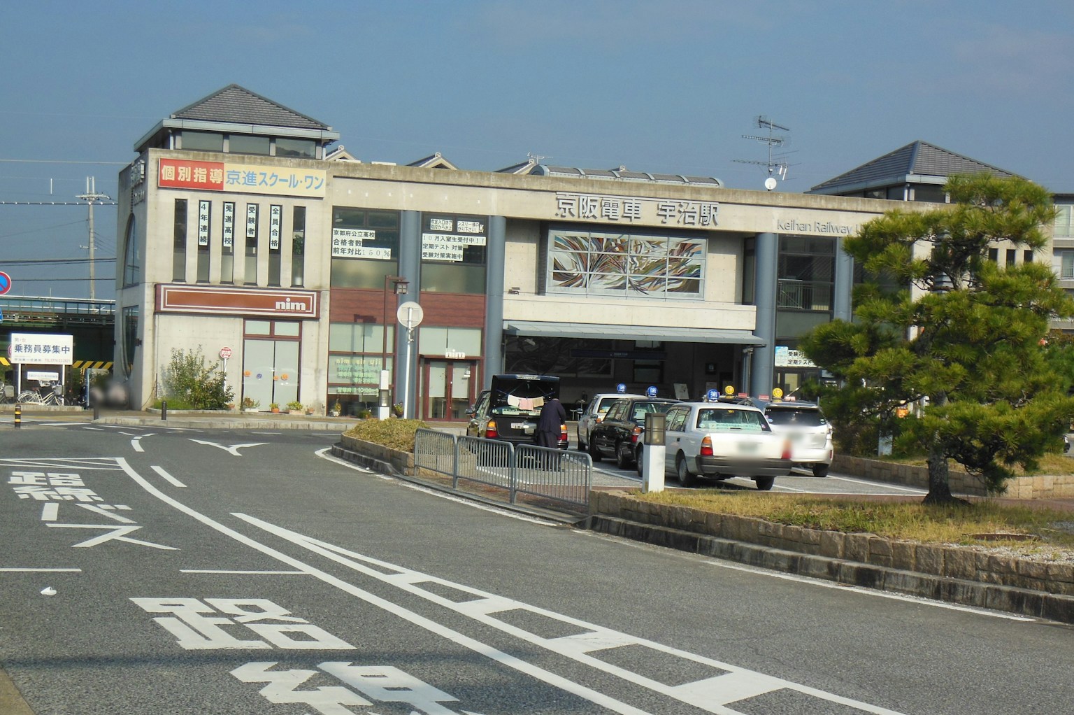 Tampilan luar stasiun kereta dengan area parkir