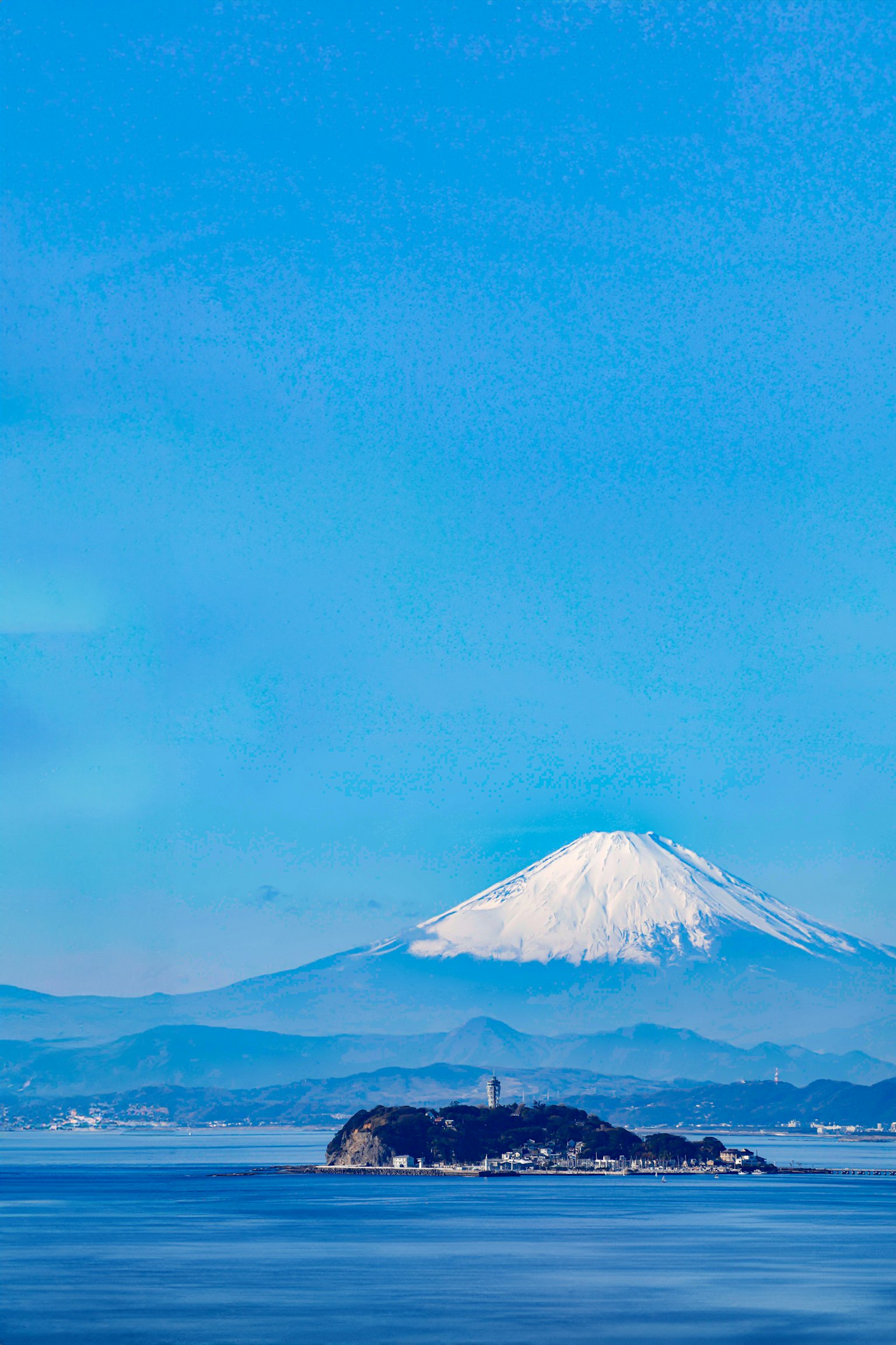 Mont Fuji enneigé sous un ciel bleu clair avec vue sur l'océan