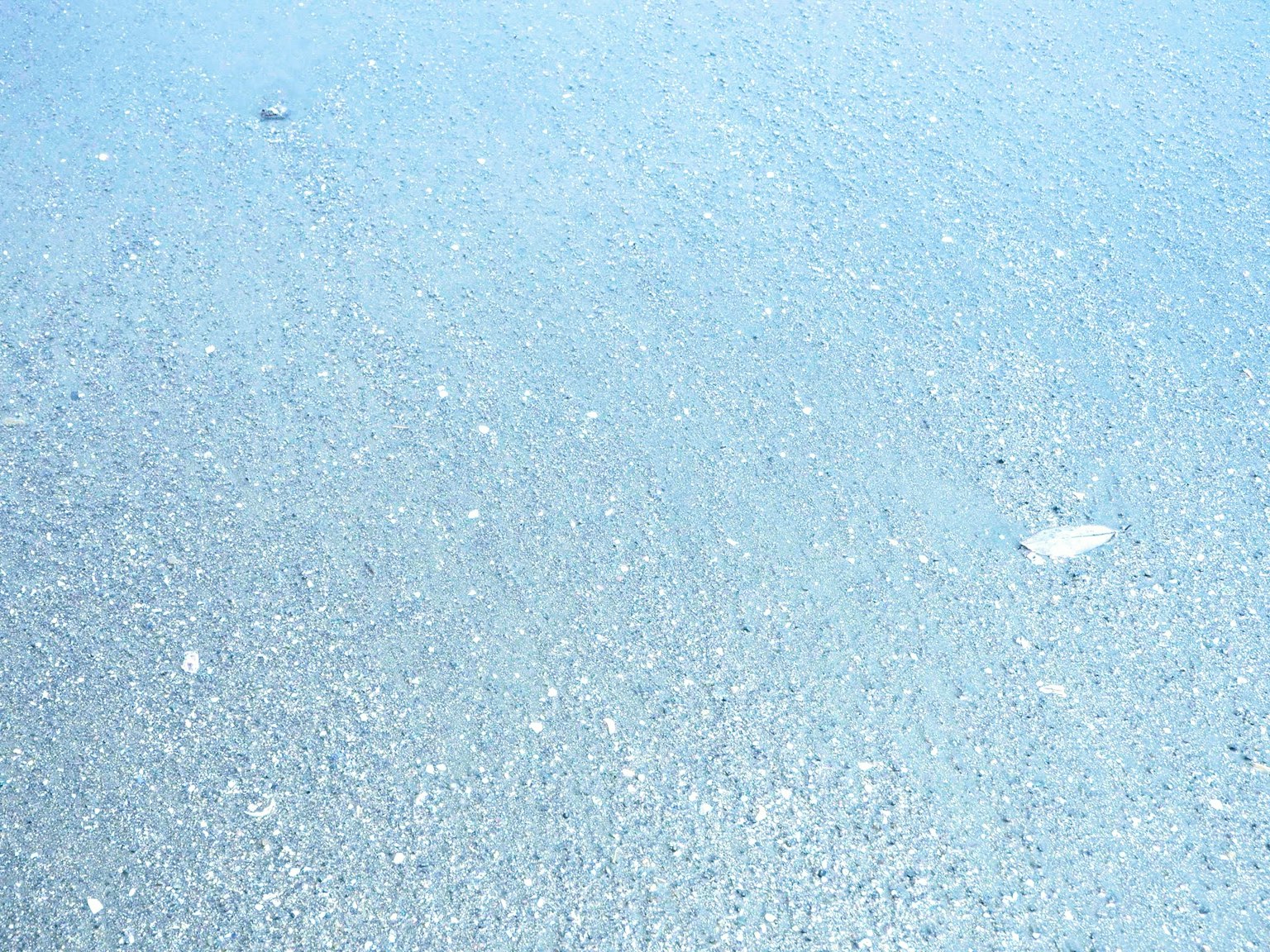 Pemandangan pantai tenang dengan permukaan laut biru bergetar