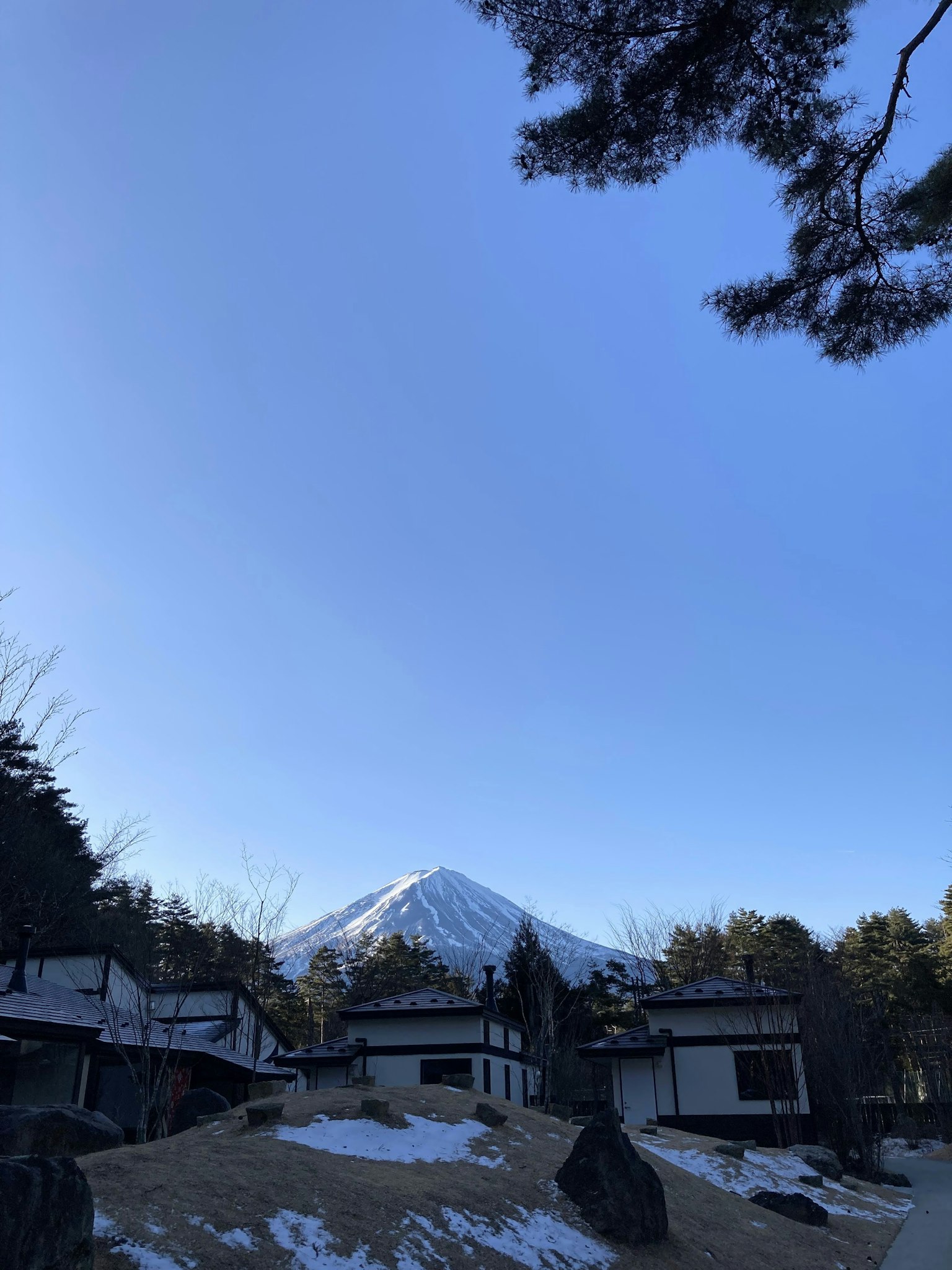 Maisons japonaises traditionnelles avec le mont Fuji en arrière-plan et un sol recouvert de neige