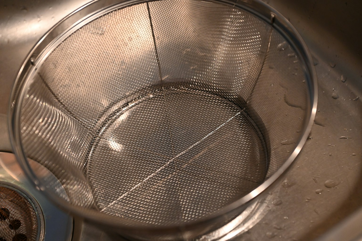Metallsieb im Wasser in einem Waschbecken