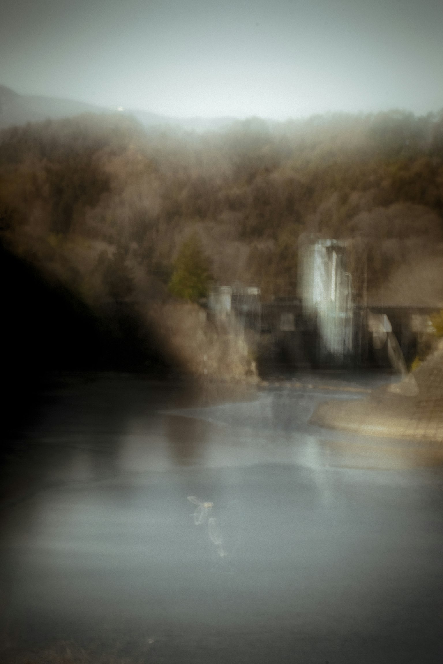 Paesaggio sfocato con una diga e acqua calma