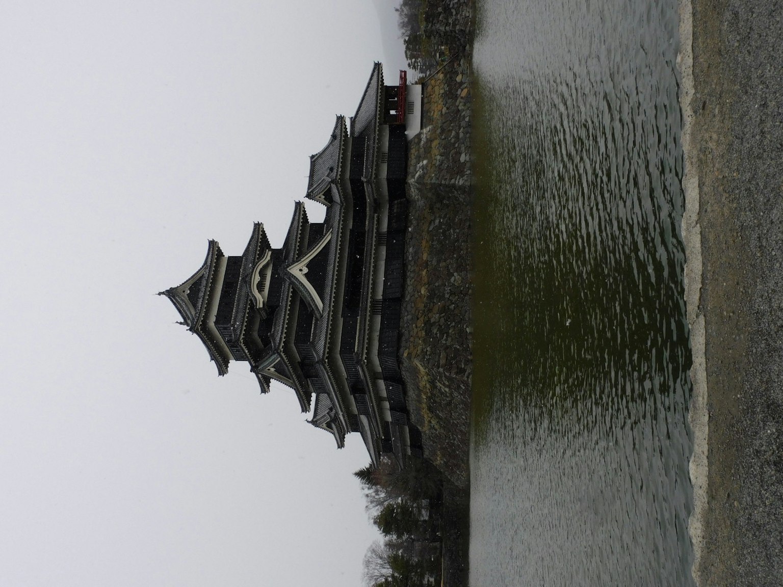 Japanese castle with black roofs reflected in a serene pond