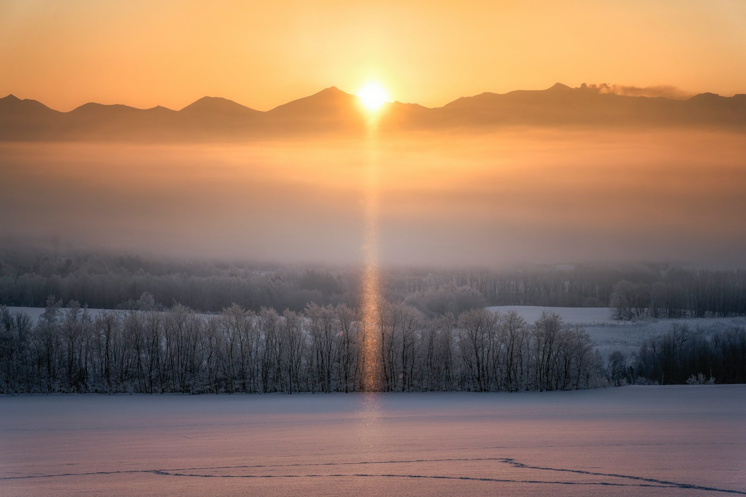 Bellissimo sorgere del sole che brilla su un paesaggio innevato