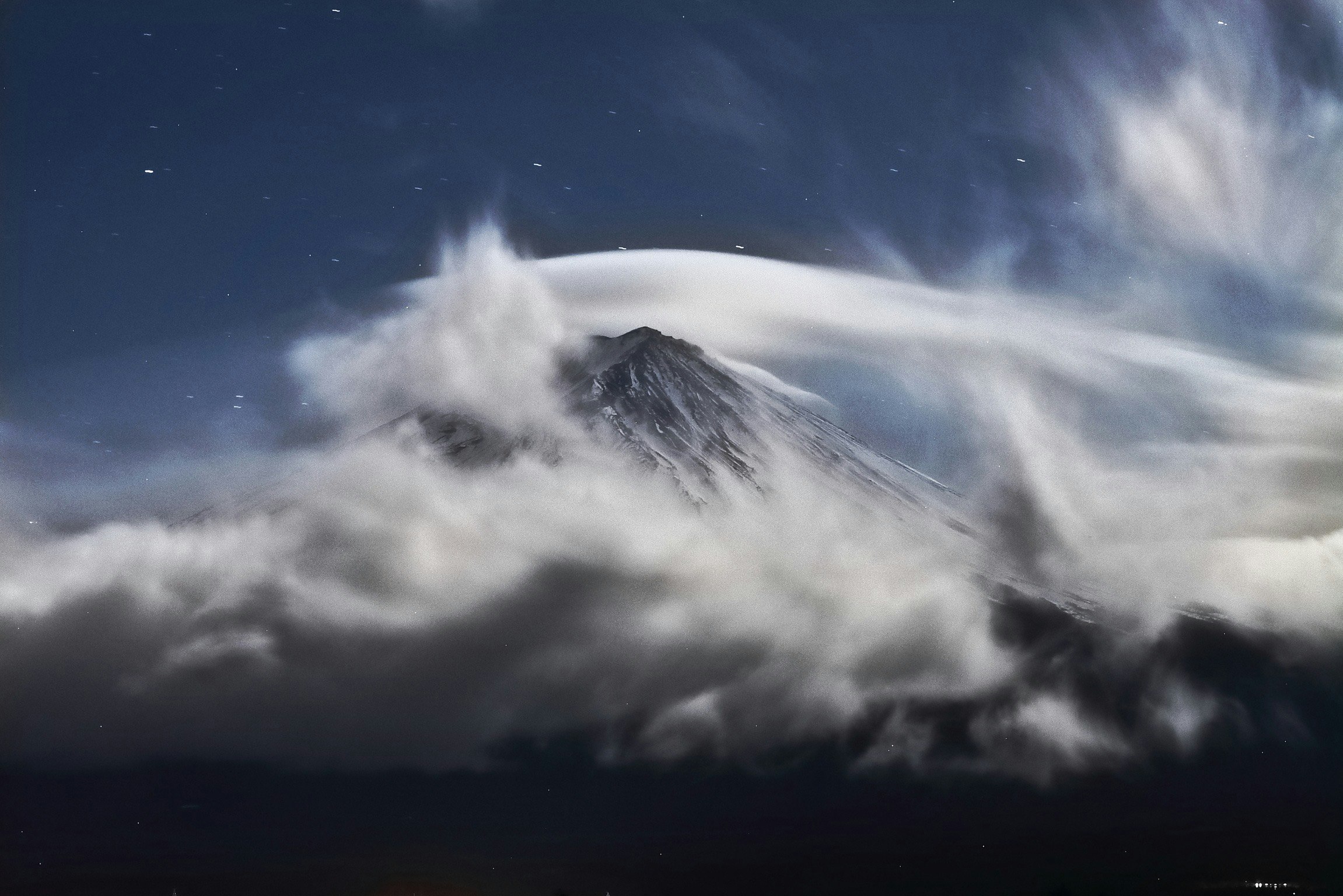 雲の上にそびえる富士山の山頂と空の景色