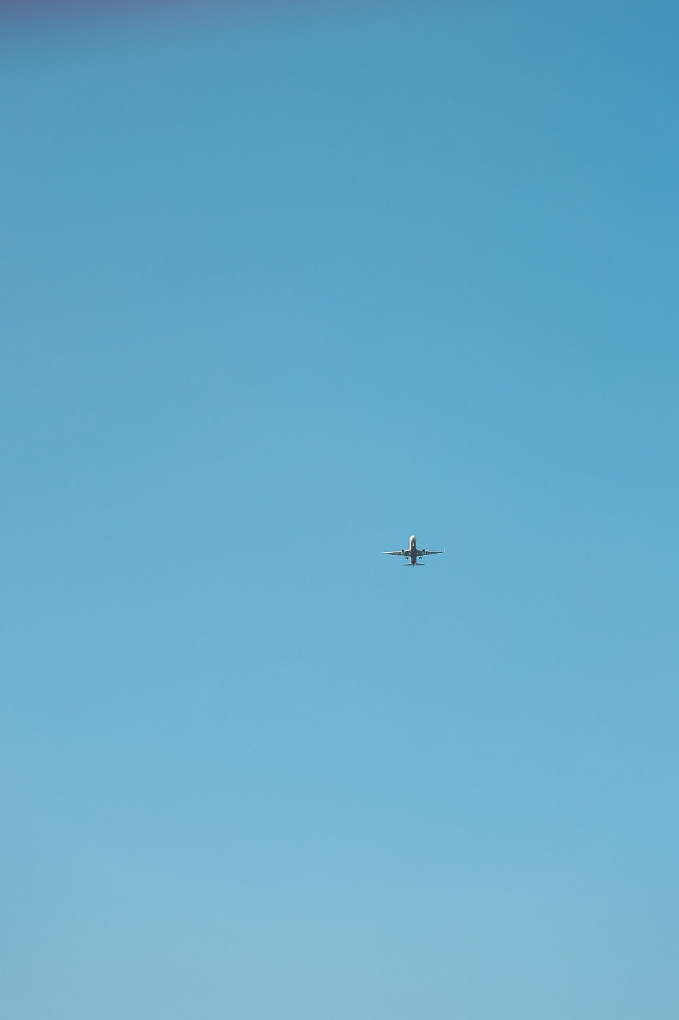 青空に小さな飛行機が飛ぶ風景