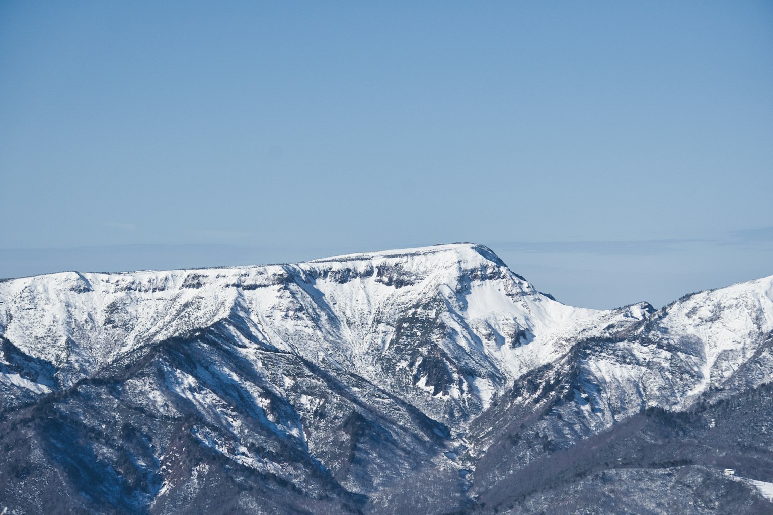 맑은 파란 하늘 아래 눈 덮인 산들