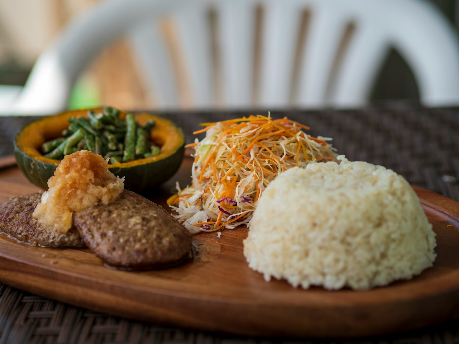 一个拼盘，包含米饭、碎菜和肉，旁边有一块南瓜