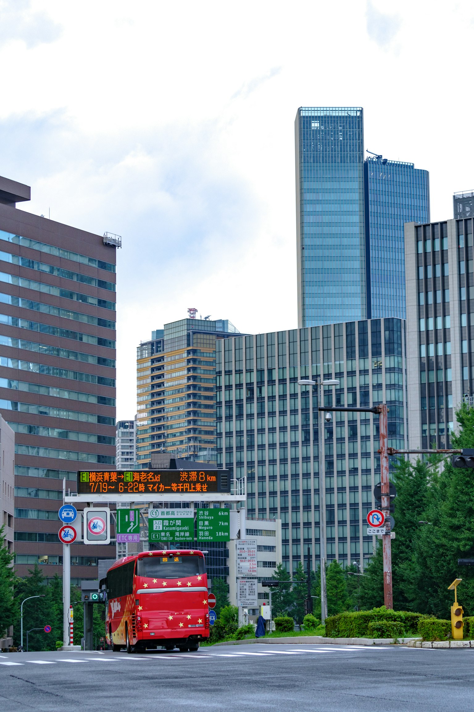City skyline featuring tall buildings and a red bus