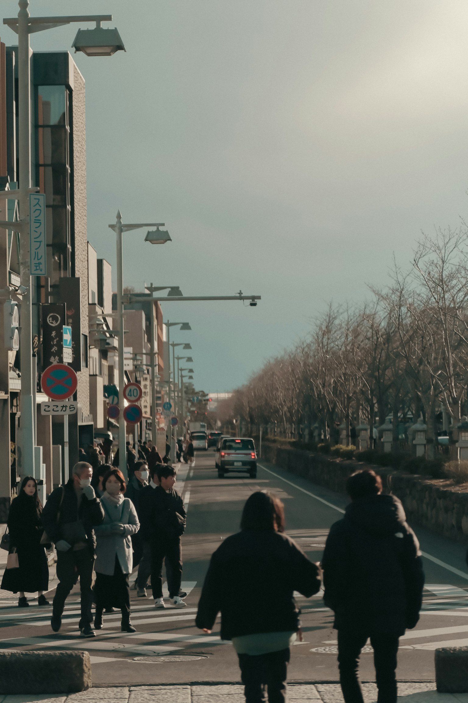 人們在街道上走，背景是建築和樹木