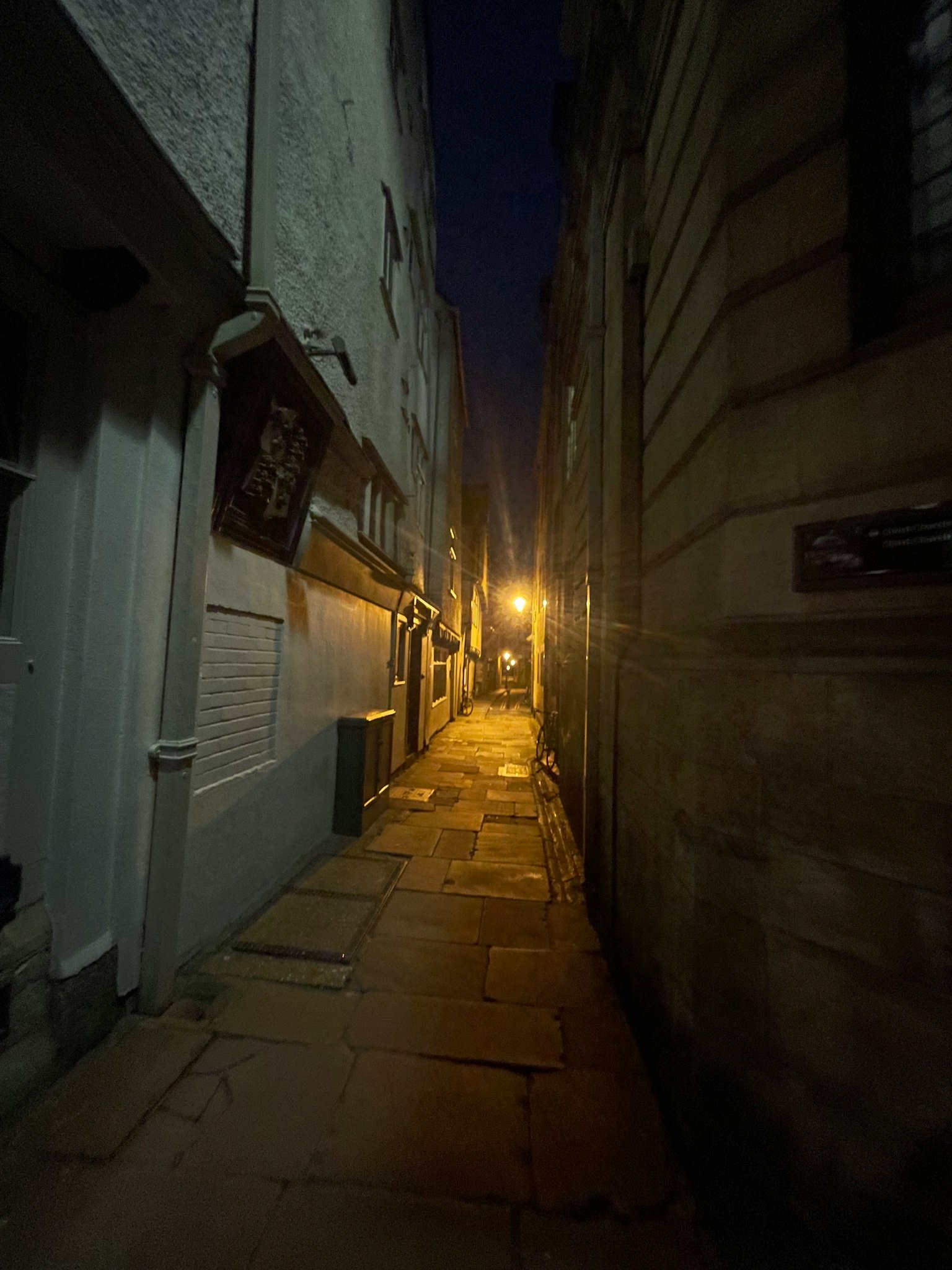 Enge Gasse bei Nacht mit einer hellen Straßenlaterne und alten Gebäuden