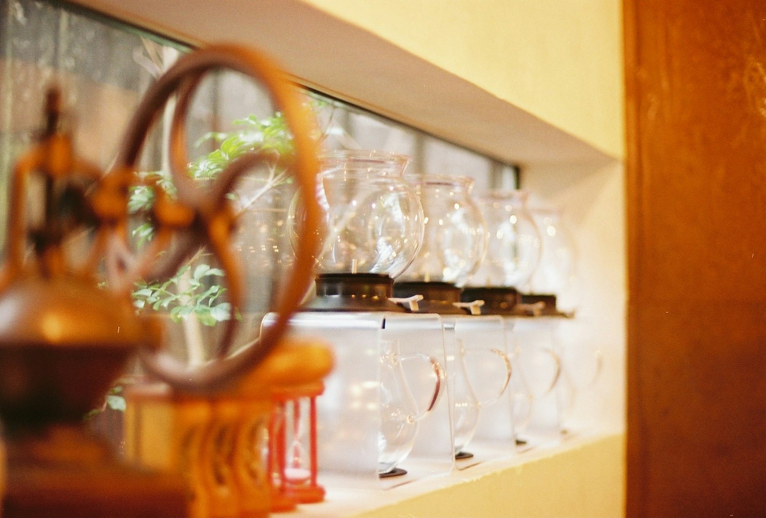 窓辺に並ぶガラス容器と古い機械の一部