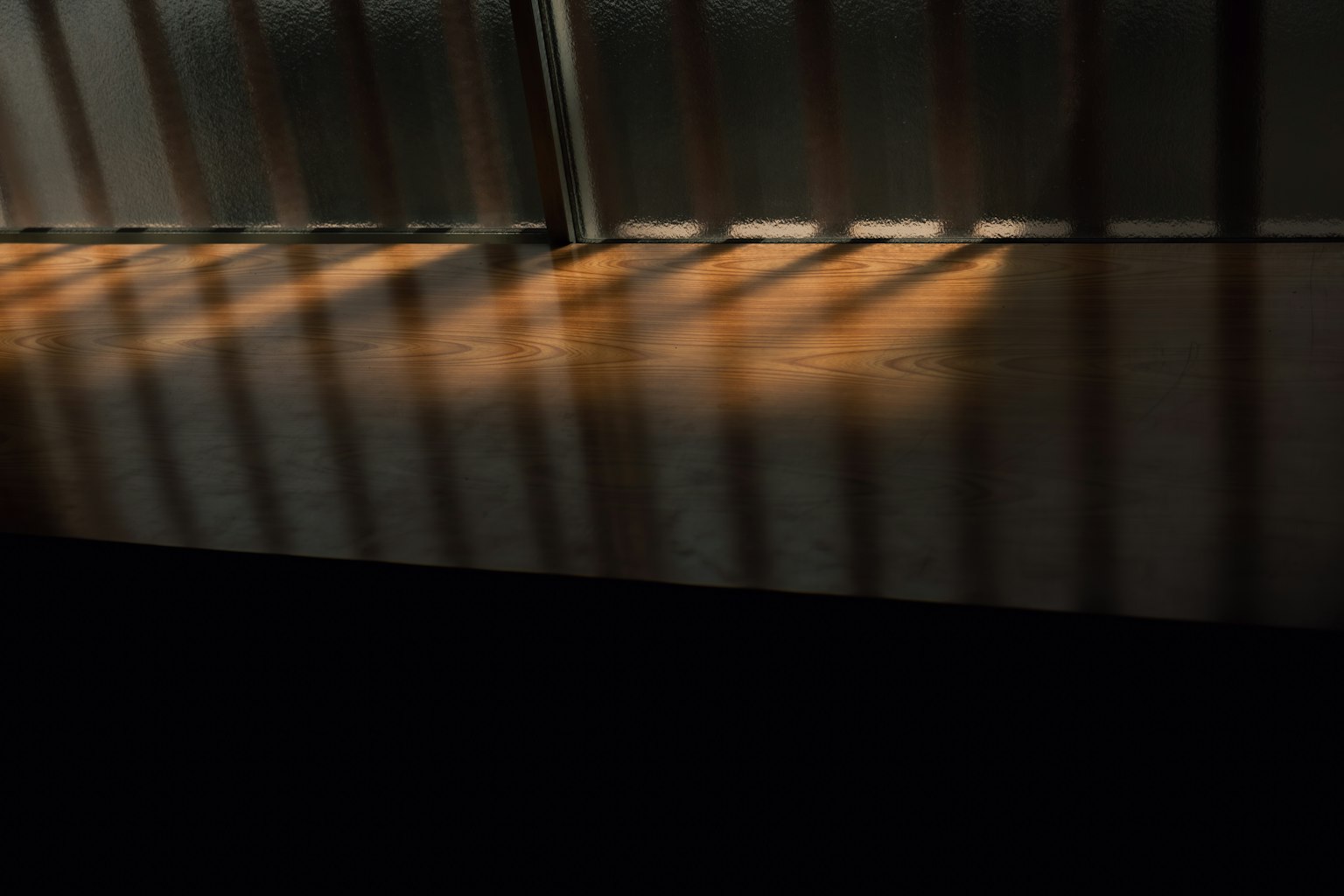 Scena interna con strisce di luce che proiettano ombre sul pavimento