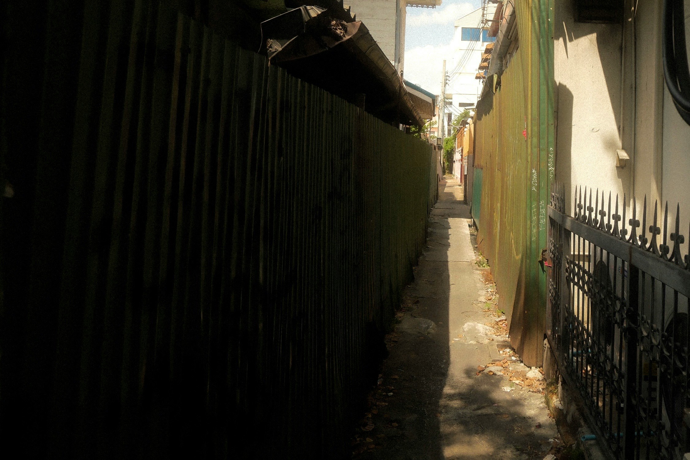 narrow alleyway corridor between tall walls leading into the distance