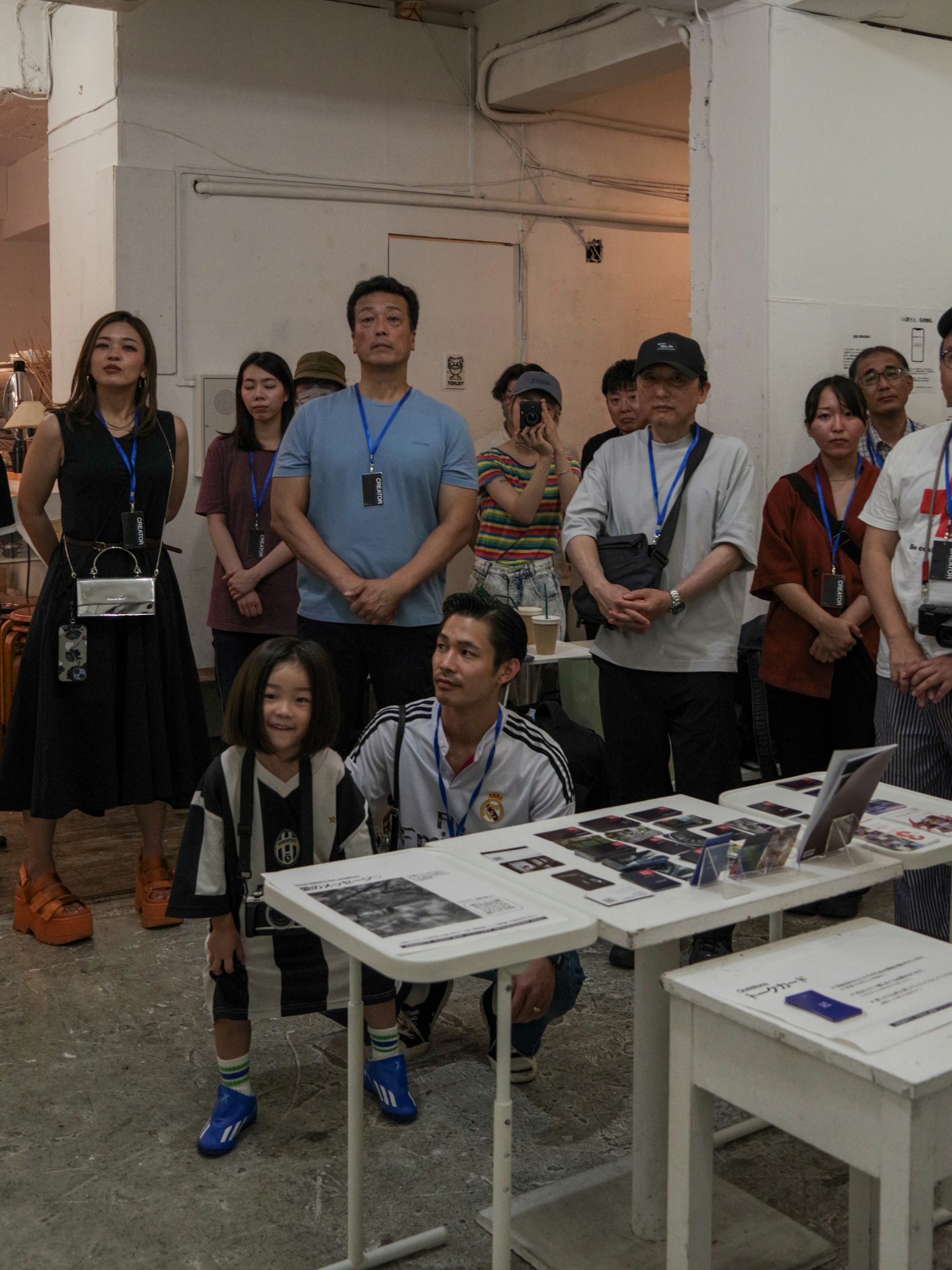 Group of people at an art gallery including adults and a child observing an exhibition