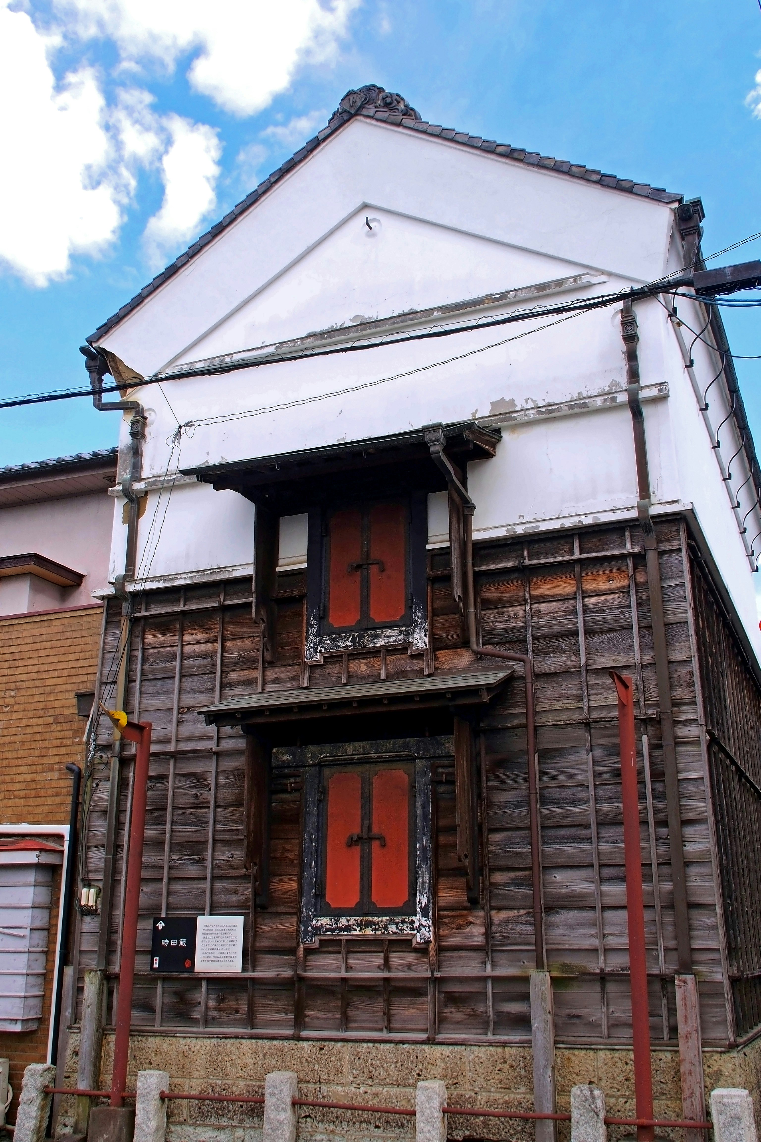 Exterior of an old wooden building with a cross decoration