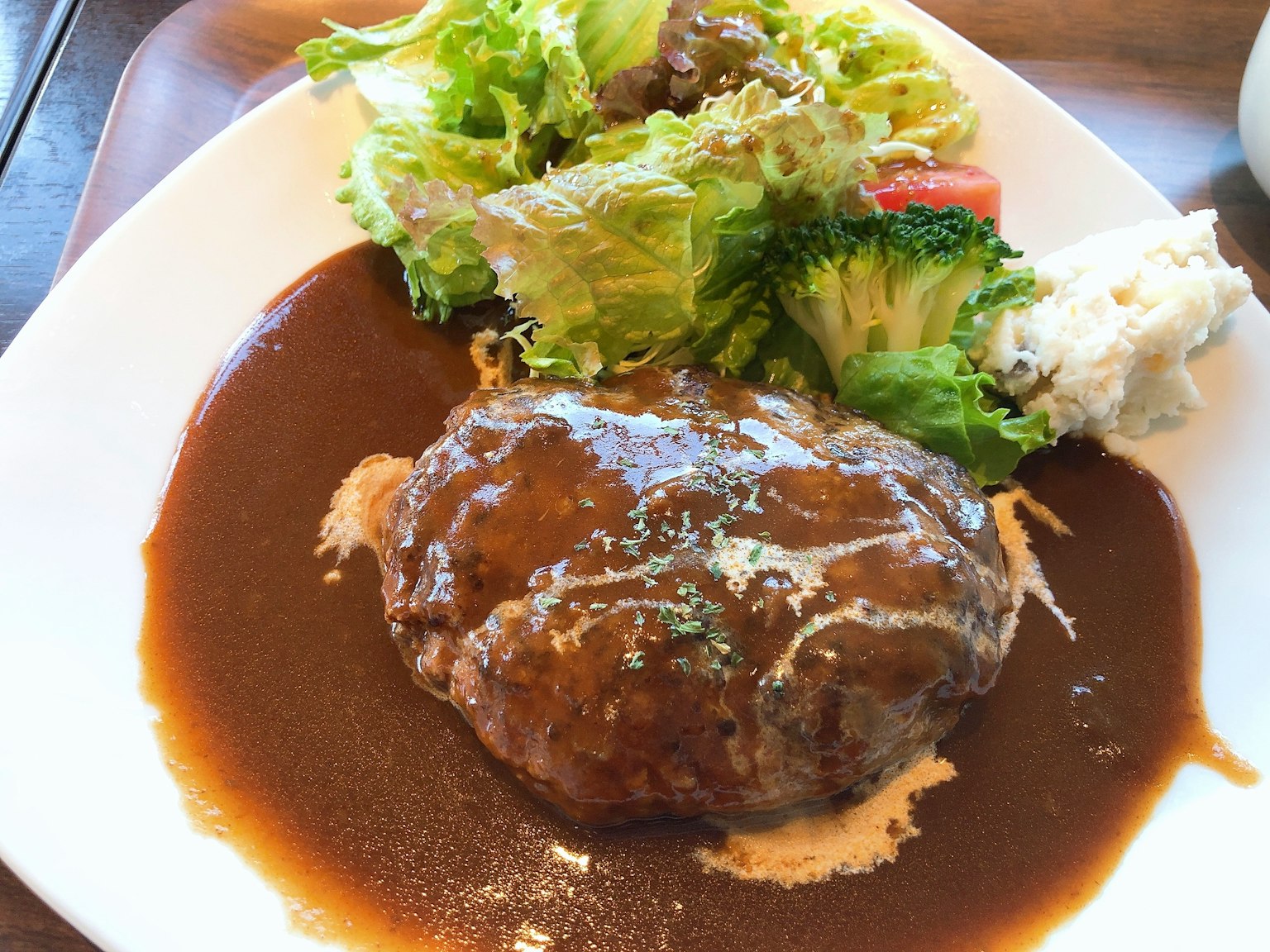 Assiette de steak haché avec sauce brune et salade fraîche