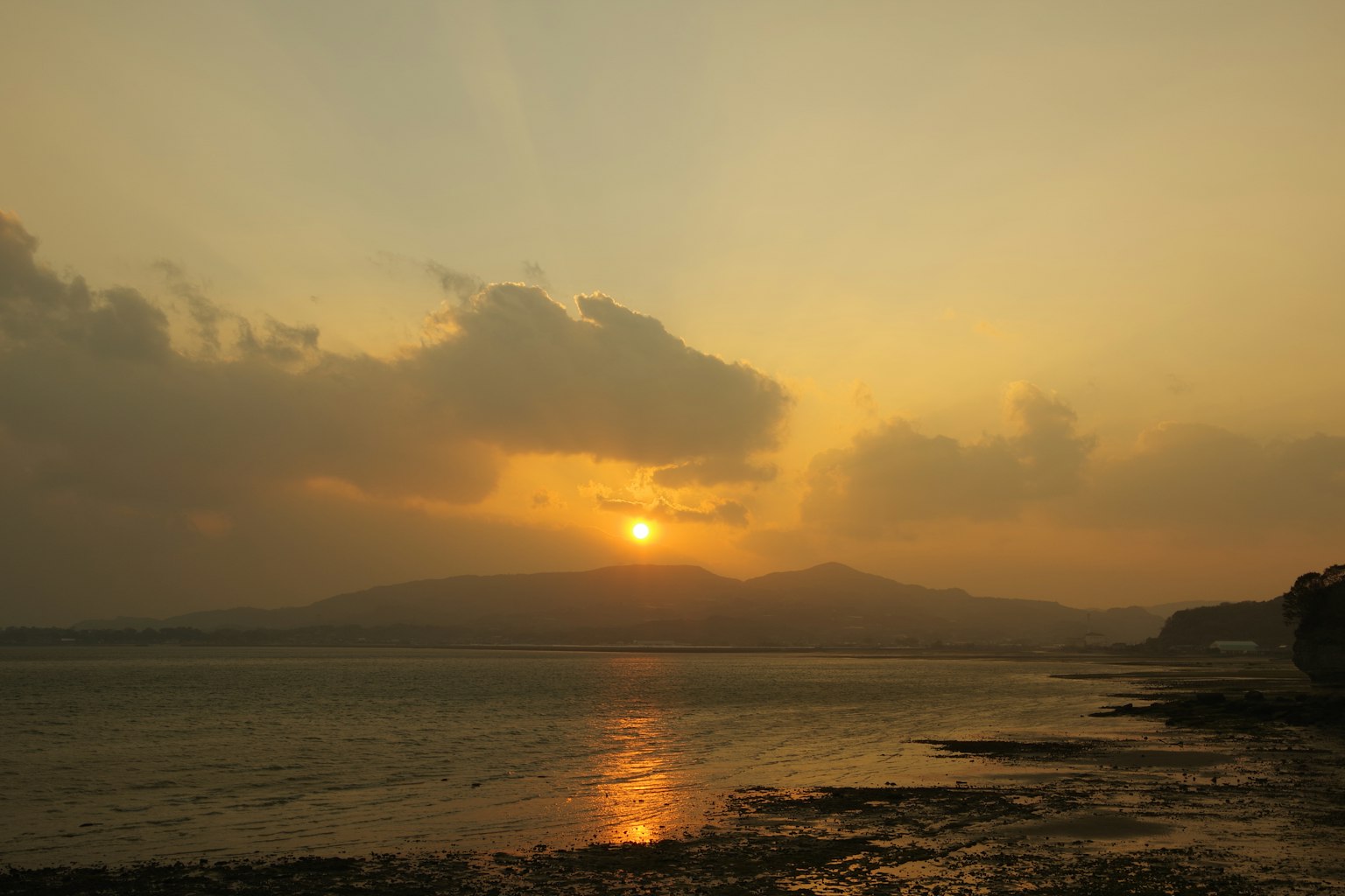 Beautiful coastal landscape with sunset behind mountains