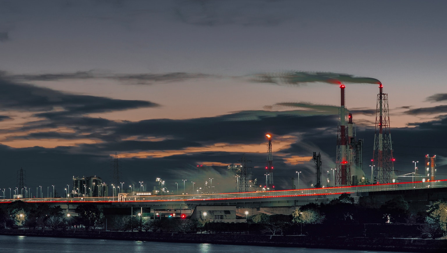 Paesaggio industriale al tramonto con grattacieli e camini