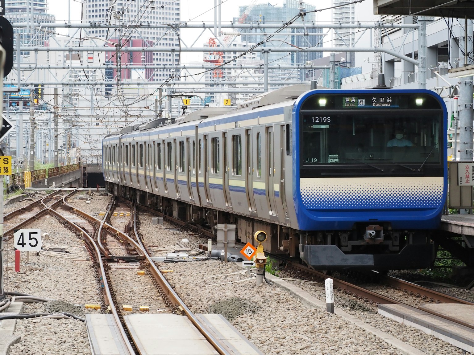 Blue train running through an urban landscape