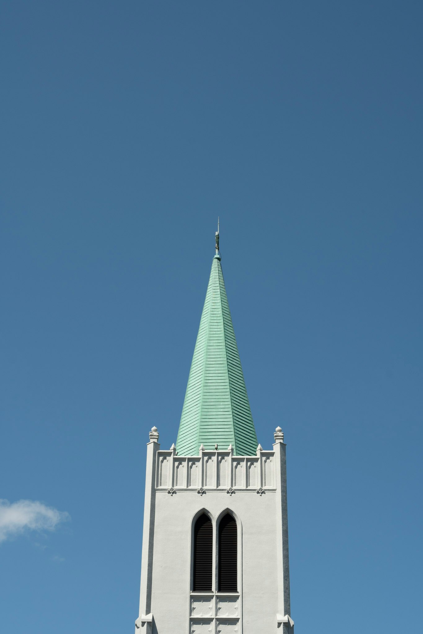 Tháp nhà thờ với ngọn nhọn màu xanh trên nền trời xanh lam