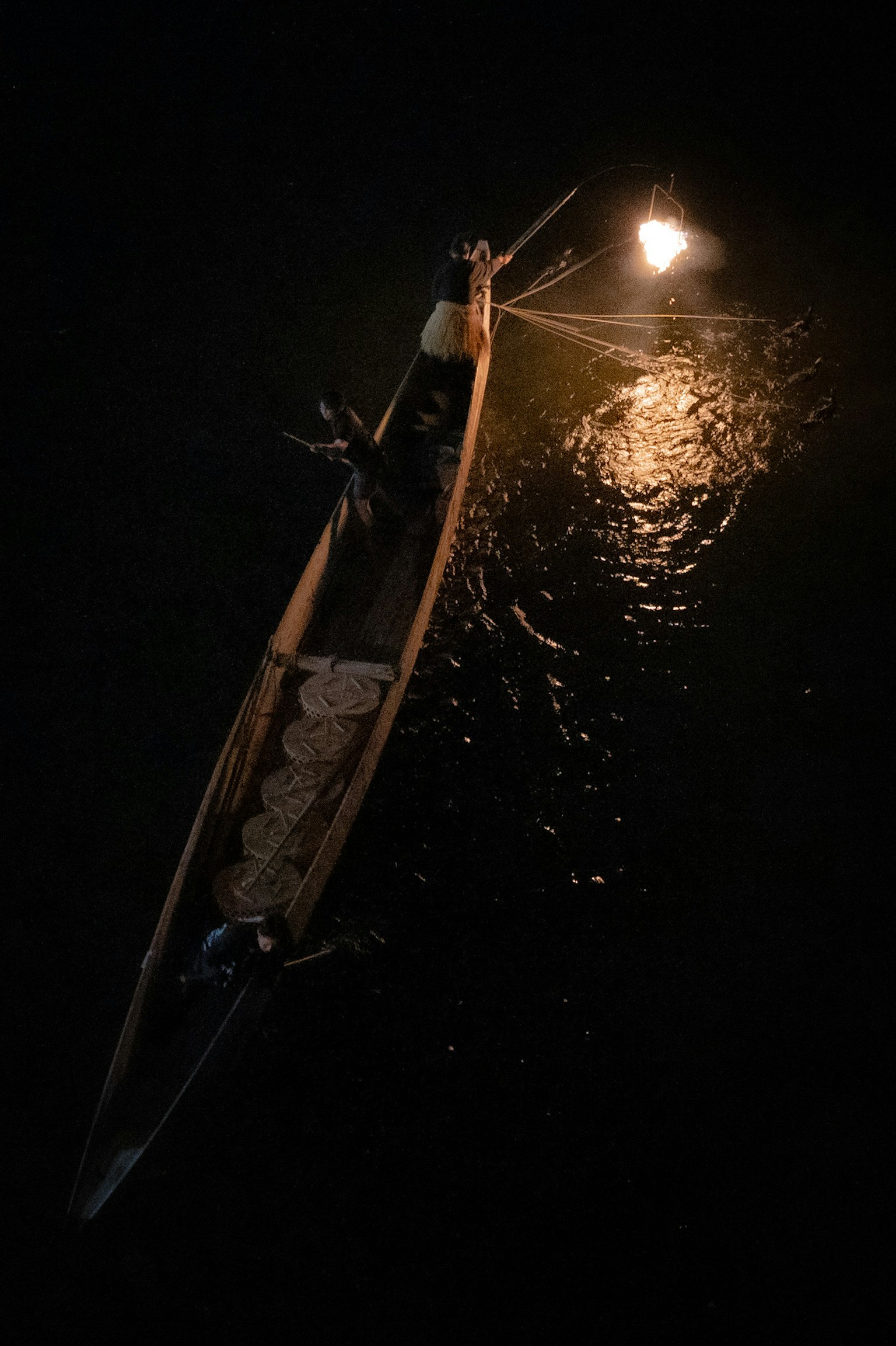 夜晚水面上被灯光照亮的小船