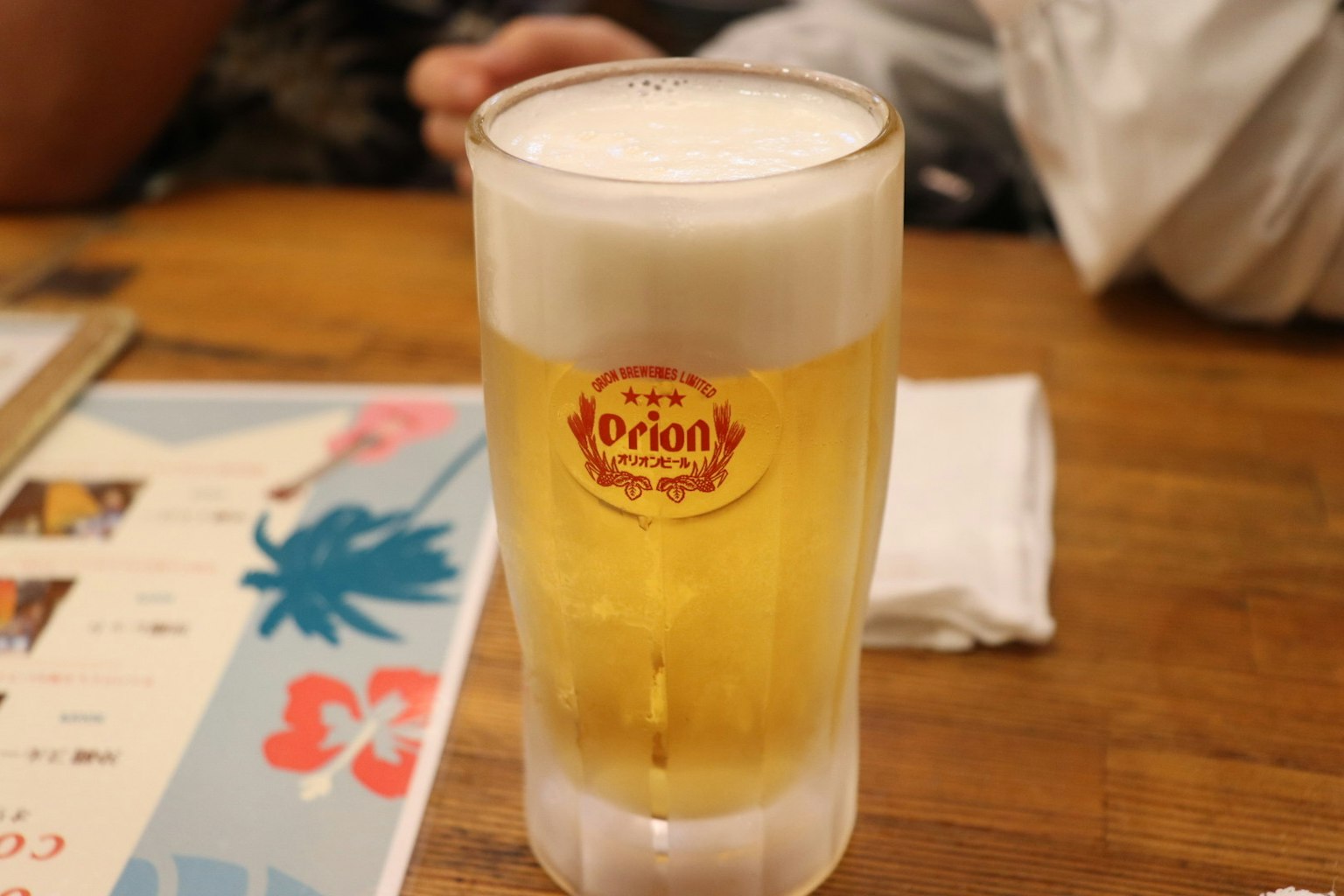 Un bicchiere di birra Orion su un tavolo di legno