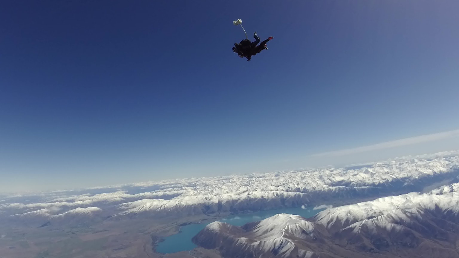 Parachutiste descendant au-dessus de magnifiques montagnes et nuages