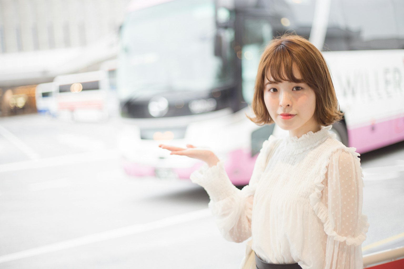 一位女性在城市环境中指向一辆公交车