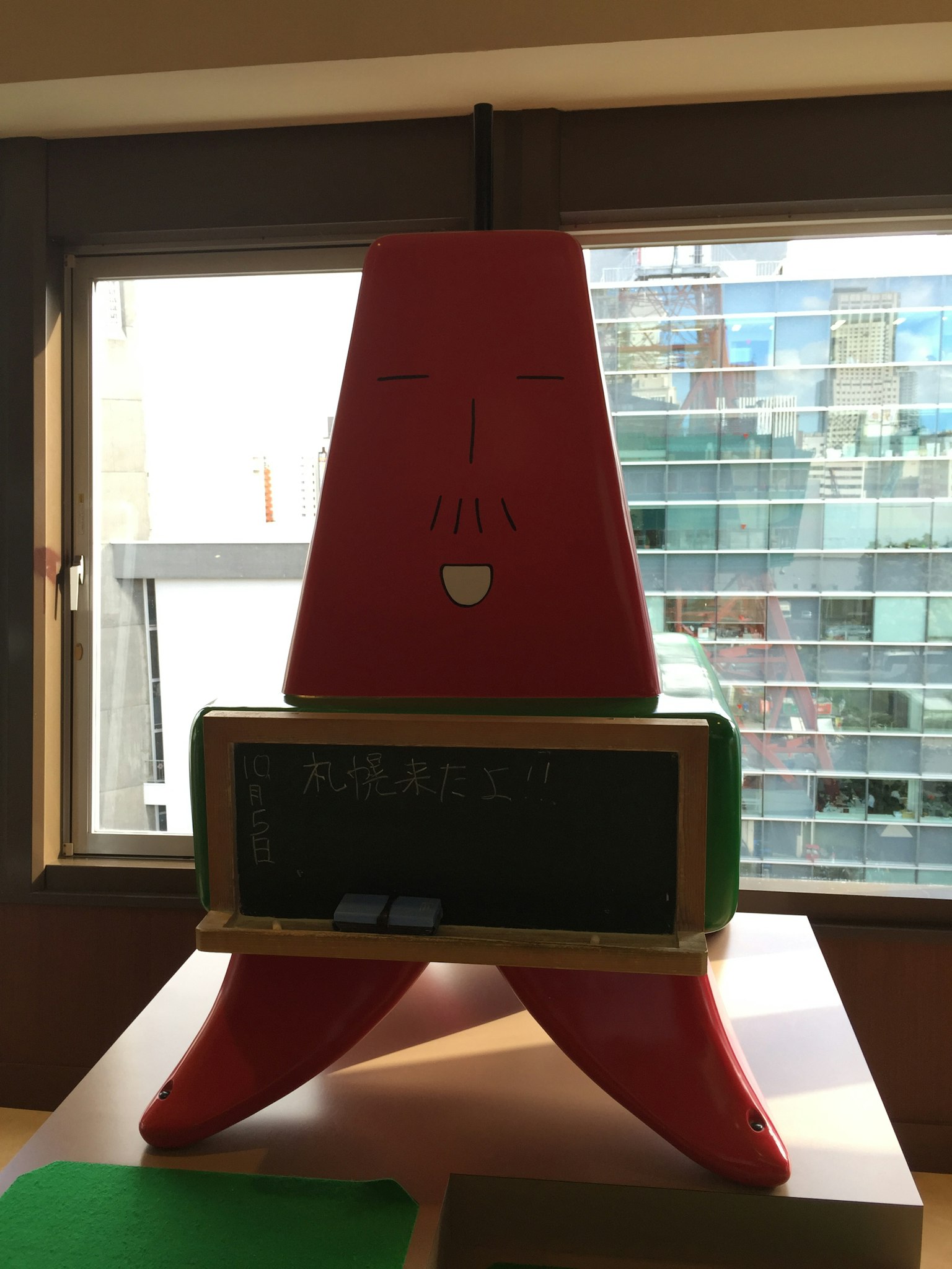 독특한 삼각형 빨간 물체와 검은색 바닥이 있는 창가 근처의 모습