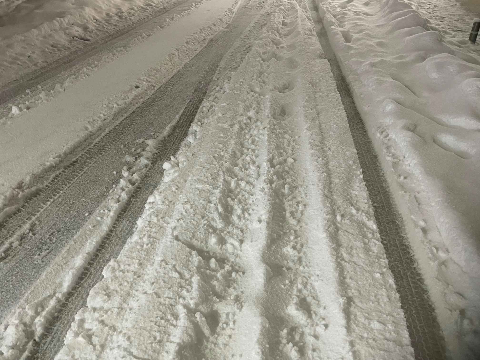 雪の積もった道路の轍と足跡のある路面
