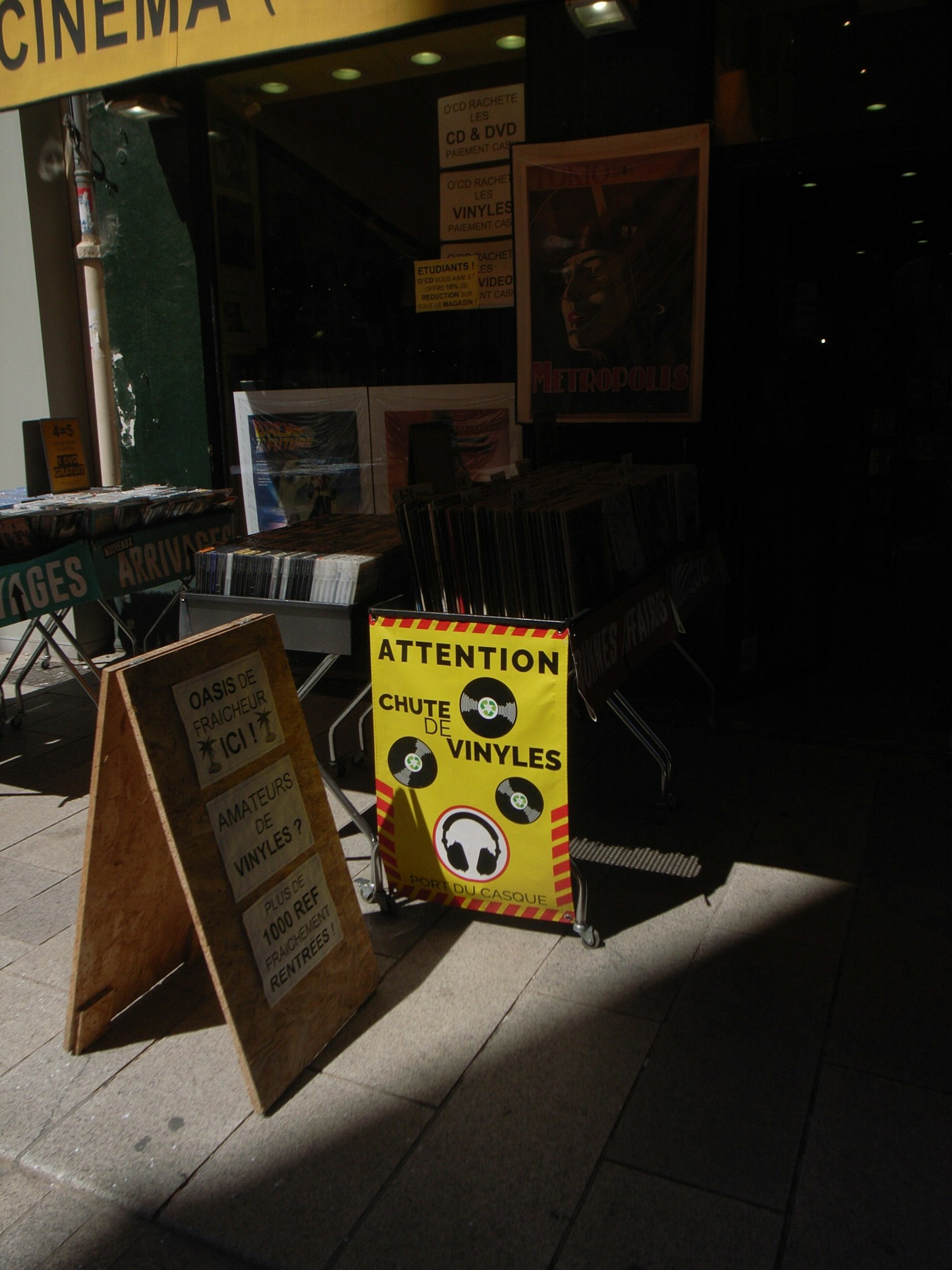 Papan kuning di luar bioskop dengan peringatan tentang vinyl