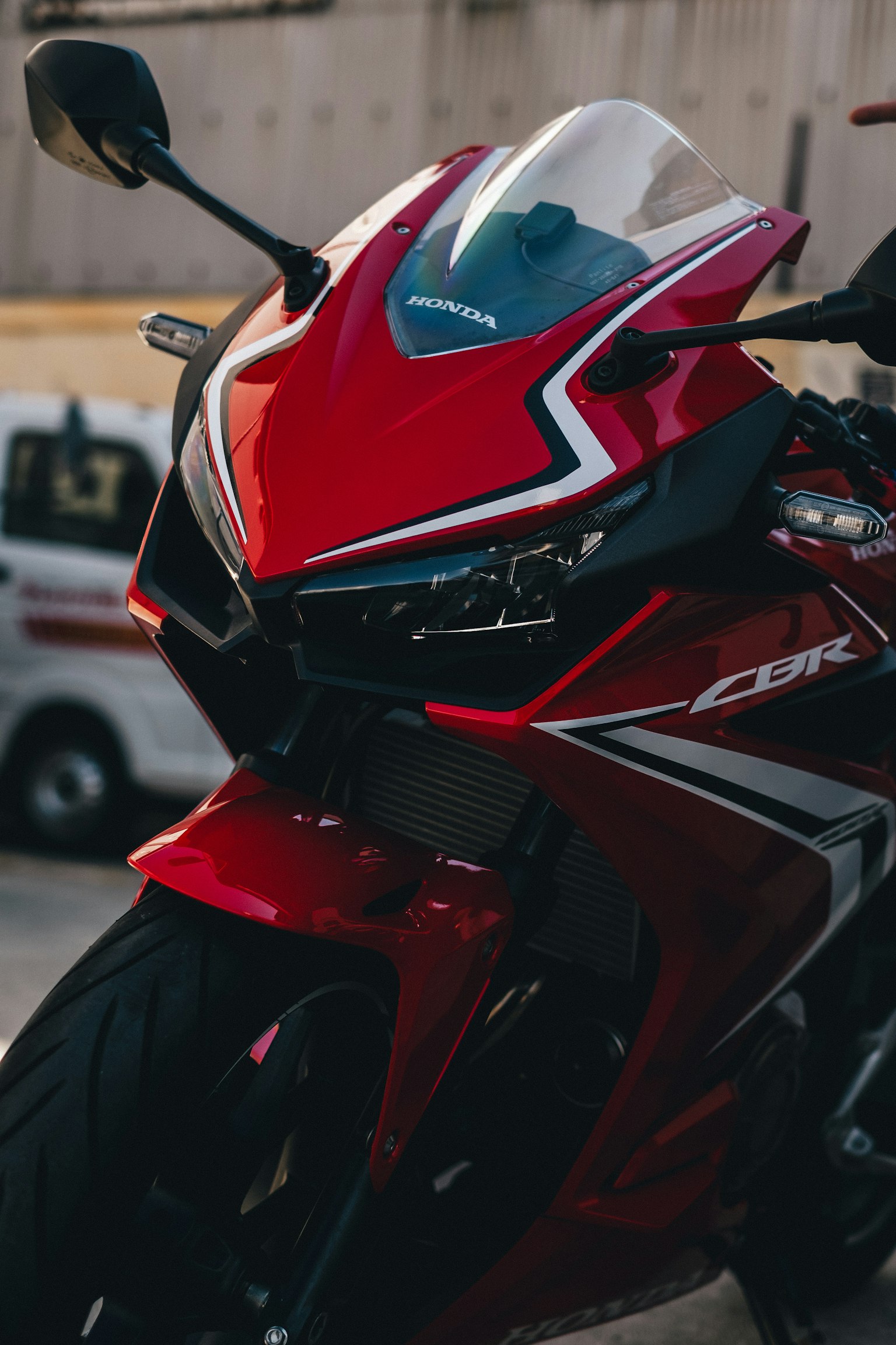 Primo piano di una moto sportiva rossa che mette in evidenza il faro e il design aerodinamico