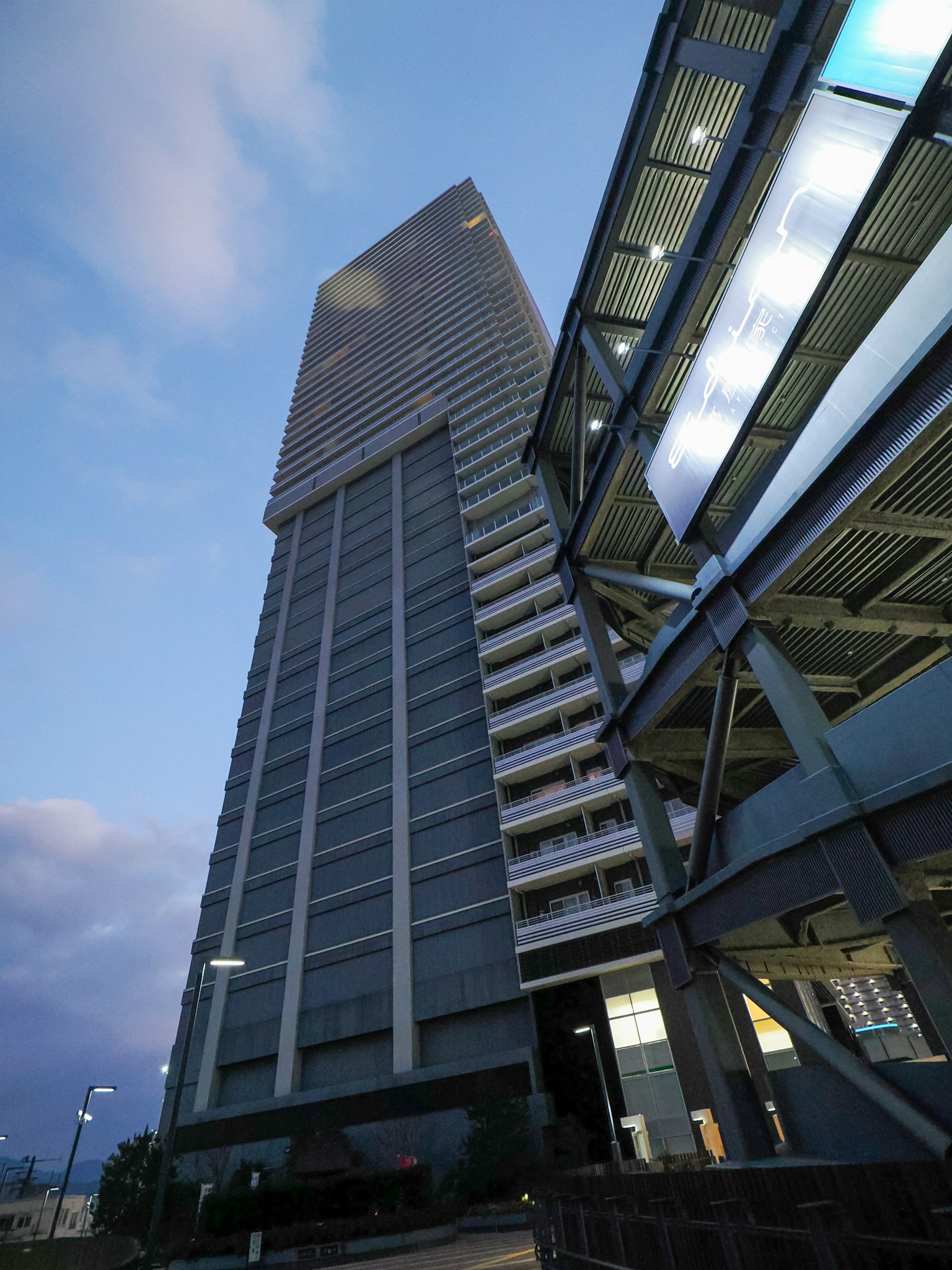 Wolkenkratzer und moderne Parkstruktur bei Dämmerung beleuchtet