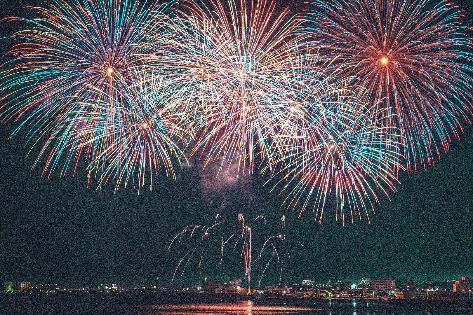 Feuerwerk über einer Uferpromenade bei Nacht