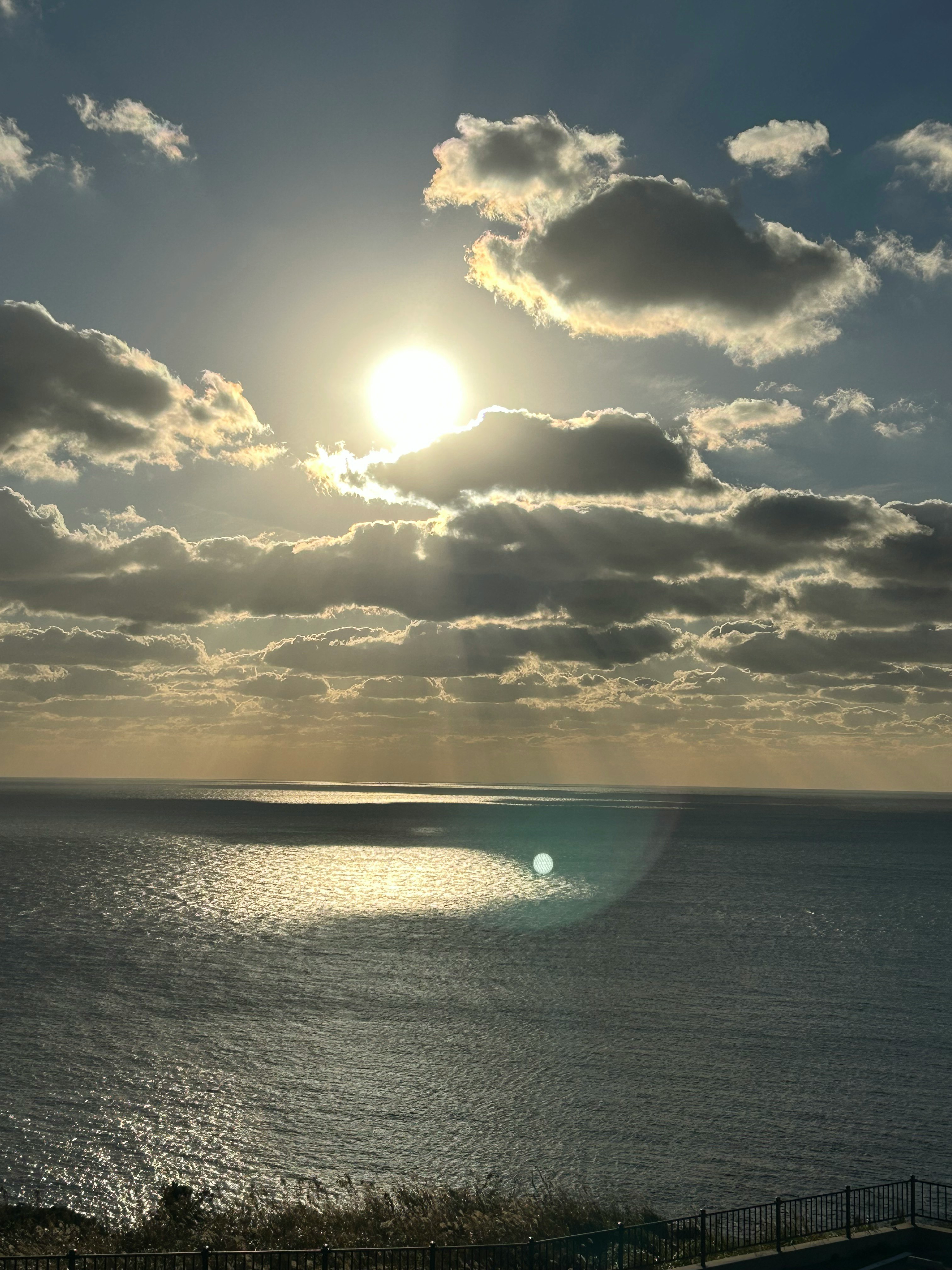 夕暮れの海に沈む太陽と雲の風景