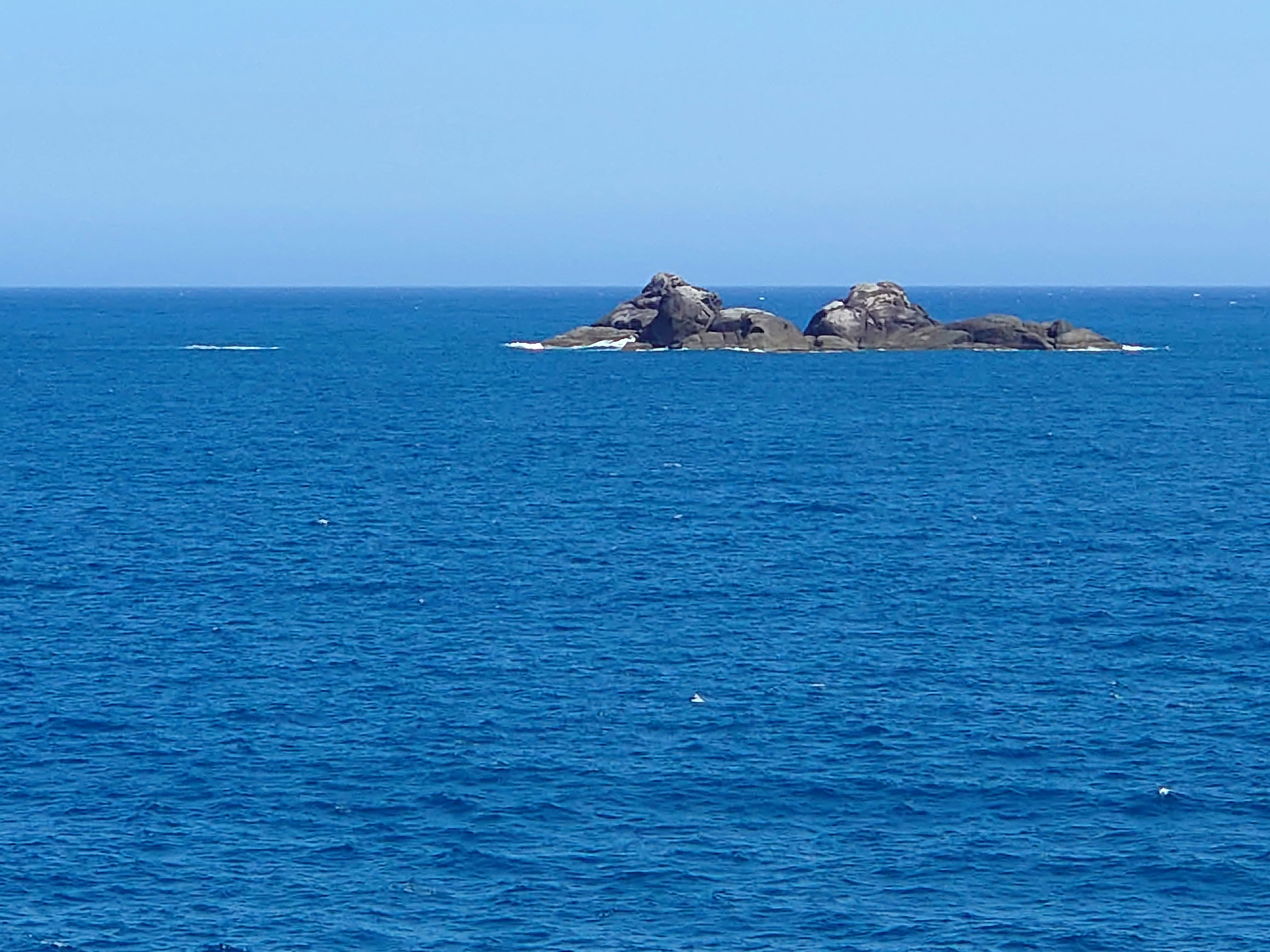 水平線と海に浮かぶ小島の景色