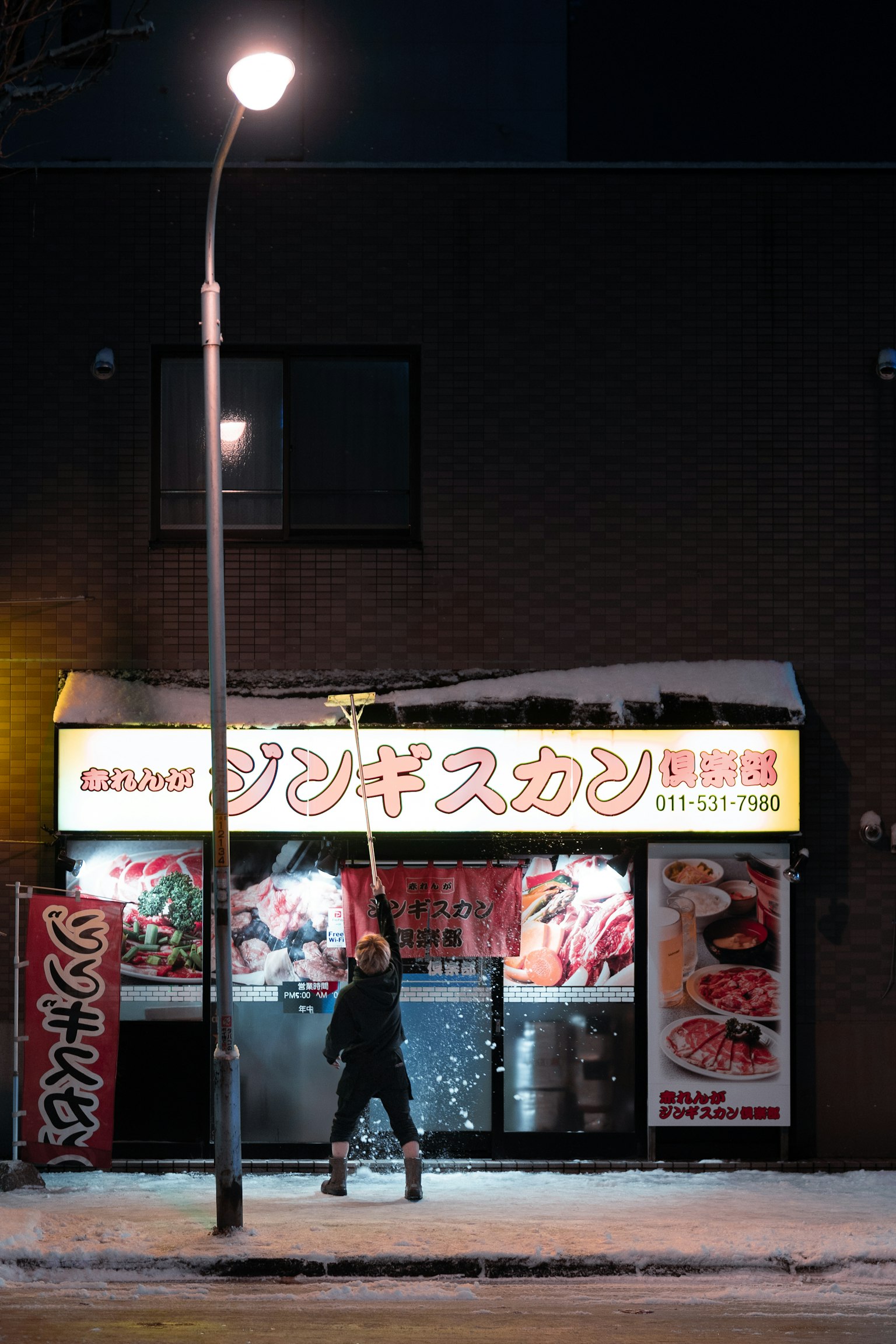 雪中在餐廳前工作的員工