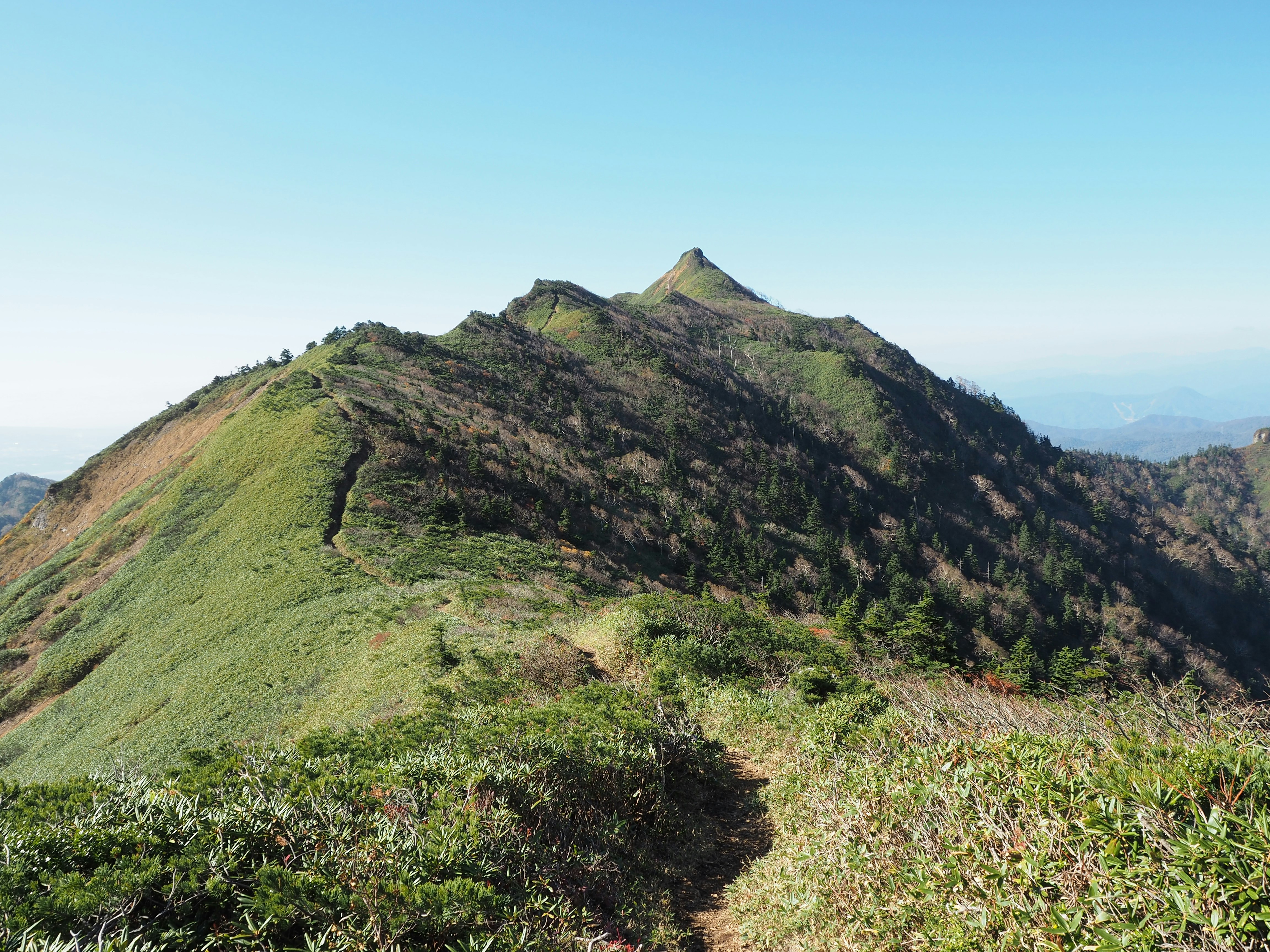 晴空下沿山脊延伸的登山步道
