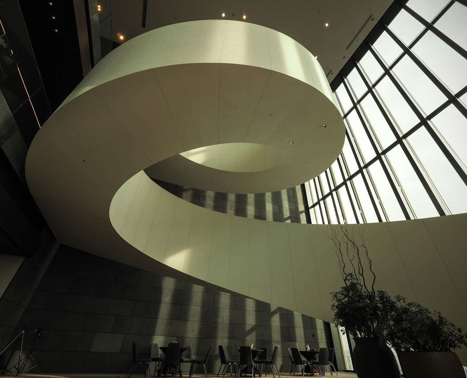 Intérieur d'un bâtiment moderne avec un escalier en spirale lisse et de grandes fenêtres