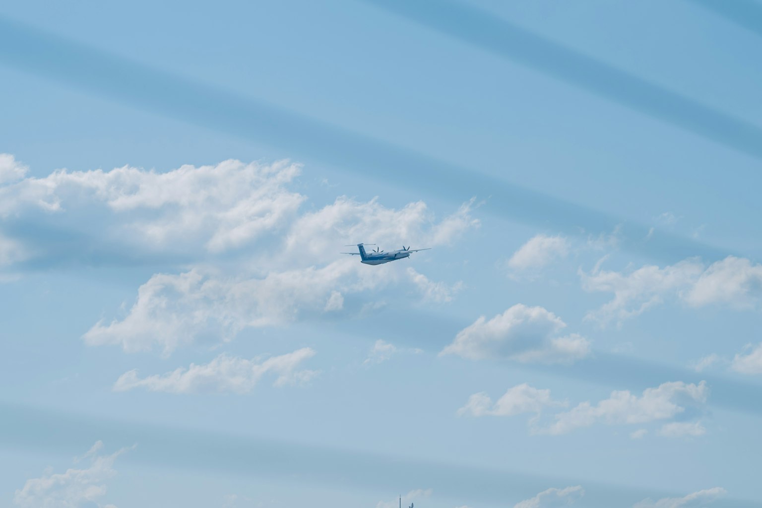Airplane flying in a blue sky with white clouds