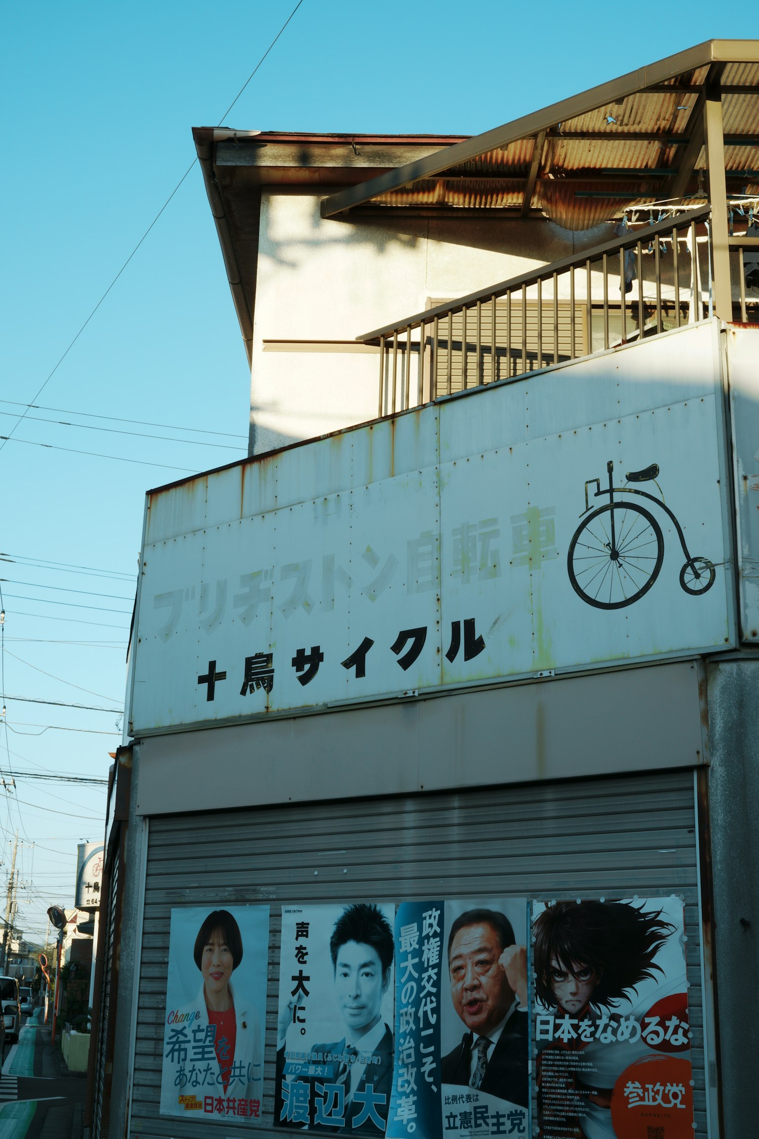 Cartel de tienda de bicicletas con carteles en una esquina de la calle