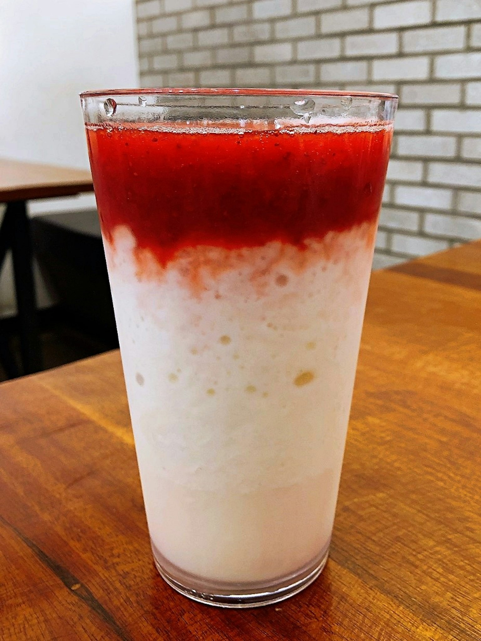 Verre de boisson crémeuse surmonté de sauce rouge